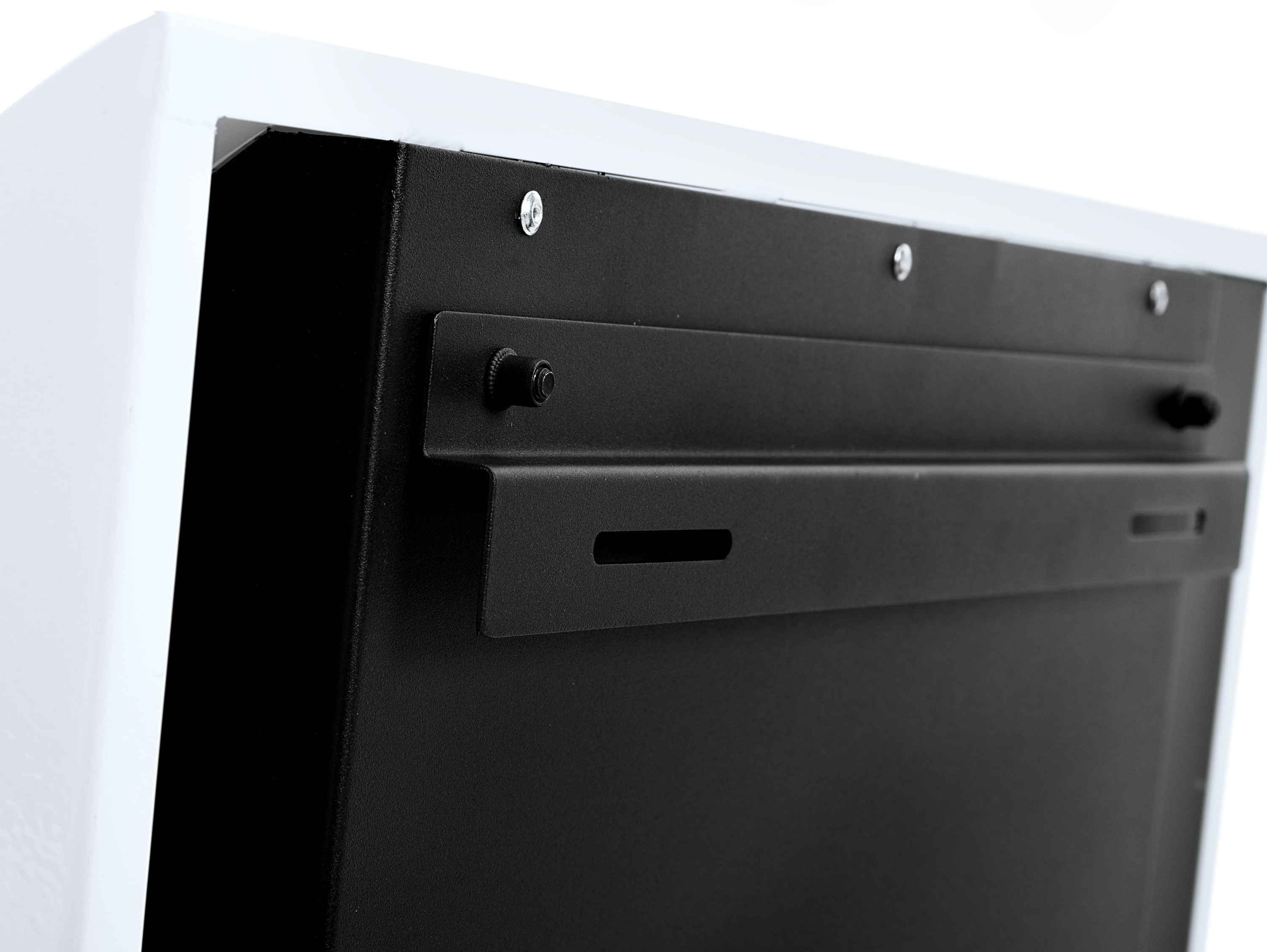 Schwarz-weißer Hintergrund mit einem schwarzen Metallteil. Das Metall hat einige kleine Löcher.