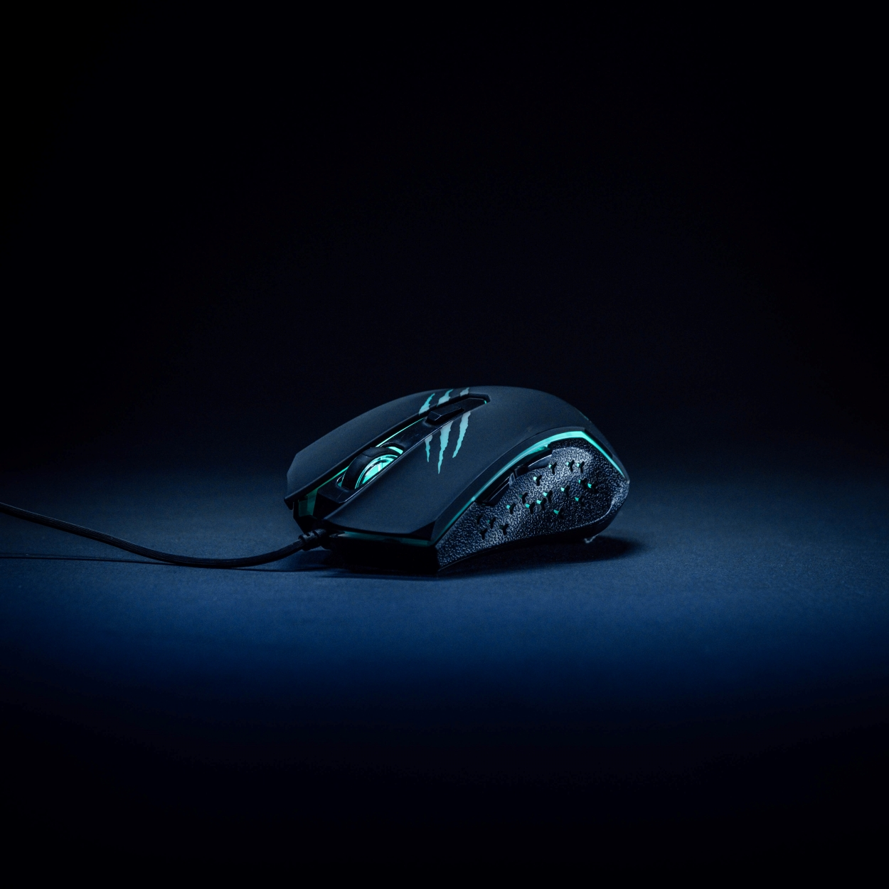 Schwarze Gaming-Maus mit blauen Akzenten auf dunkelfarbigem Untergrund.