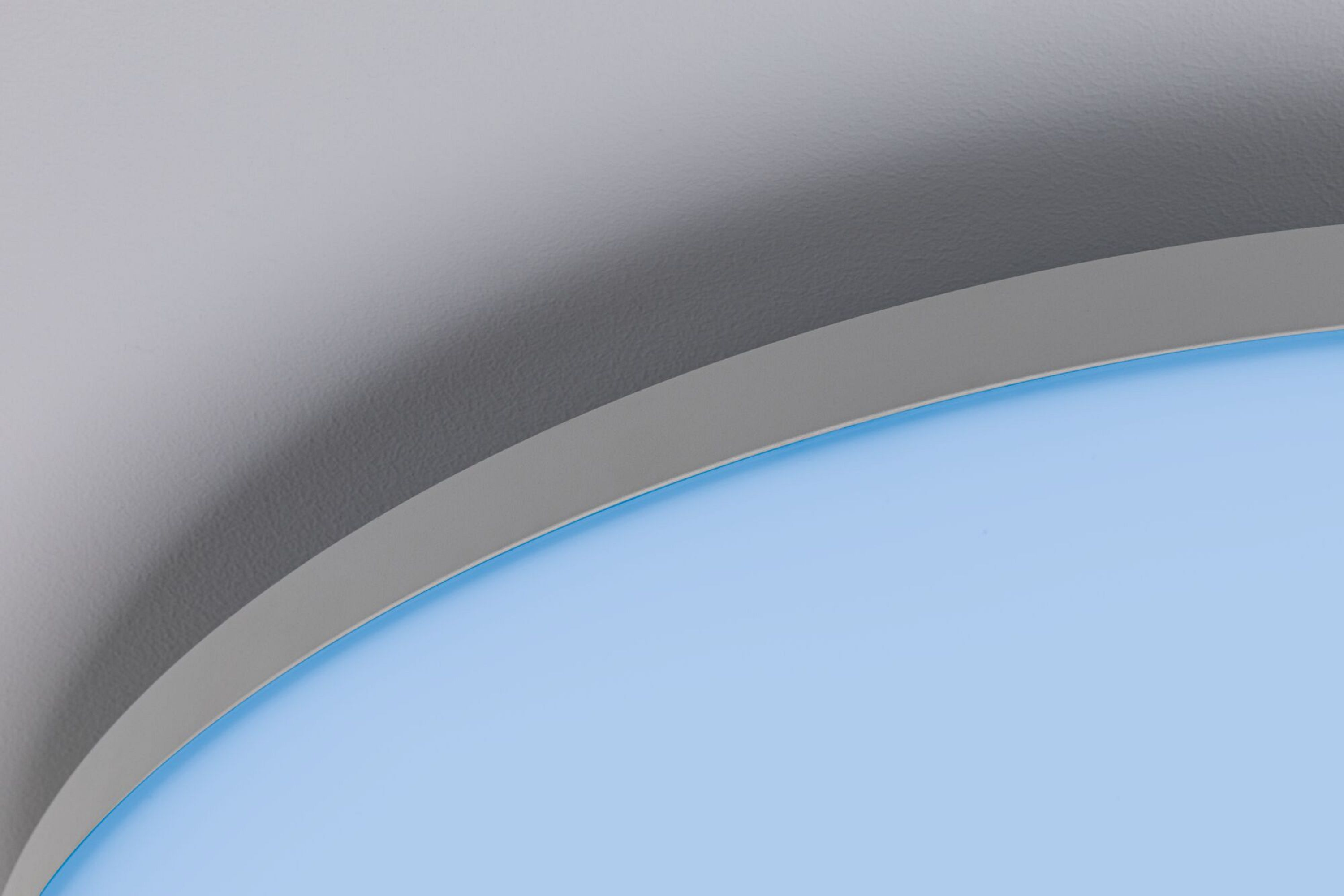 Abstrakcyjny widok zakrzywionej powierzchni, jasnoniebieskie tło z szarą górną krawędzią.