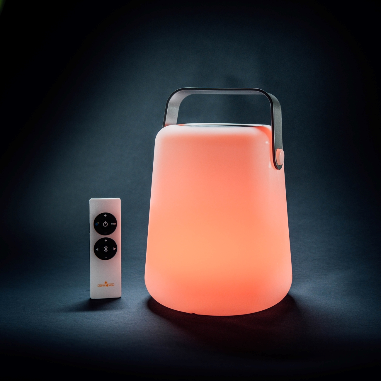 Weiß-orangefarbene Lampe mit Fernbedienung, dunkler Hintergrund.