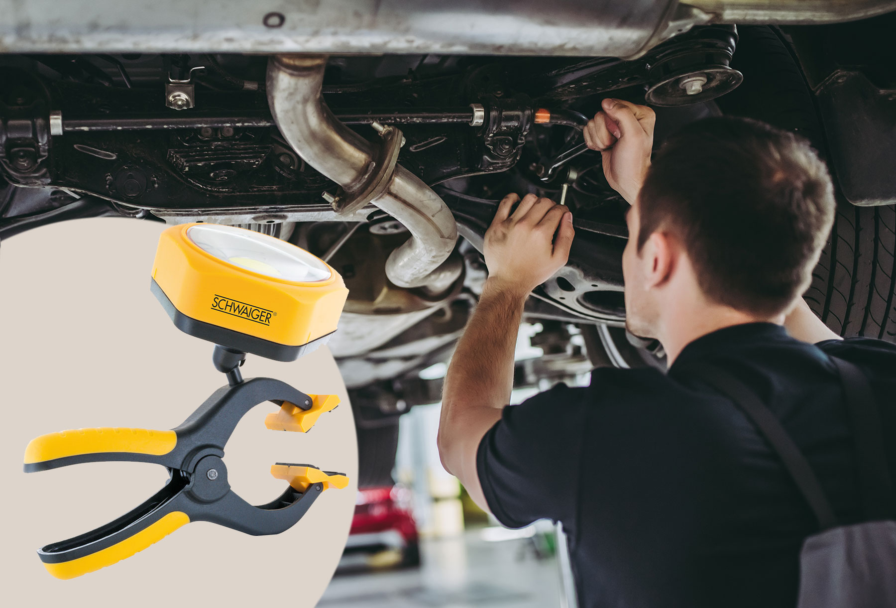 Mechaniker arbeitet unter einem Auto mit einer Klemmleuchte, gelb und schwarz.