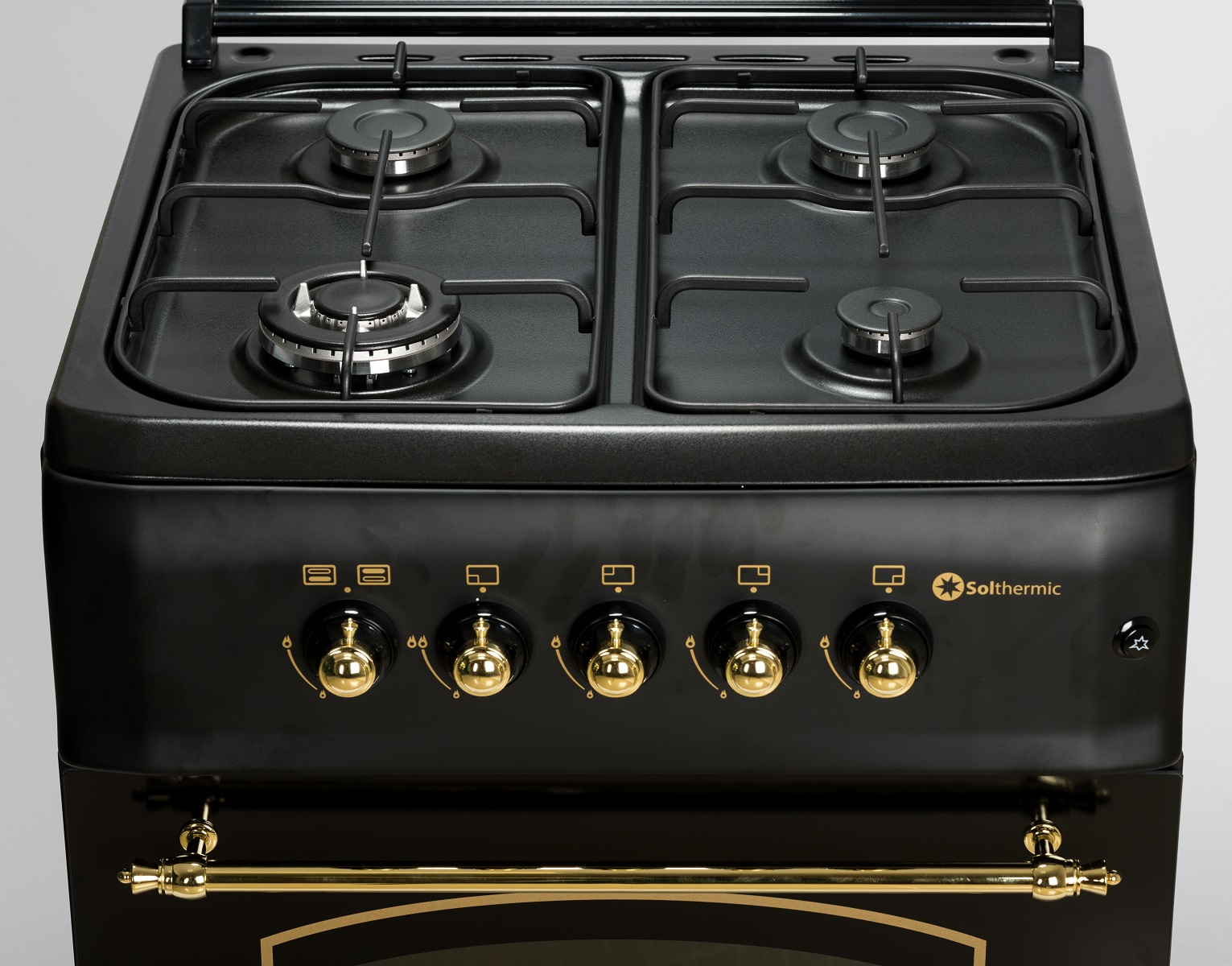 Cocina negra con 4 quemadores y perillas doradas. El frente tiene la marca Solthermics.