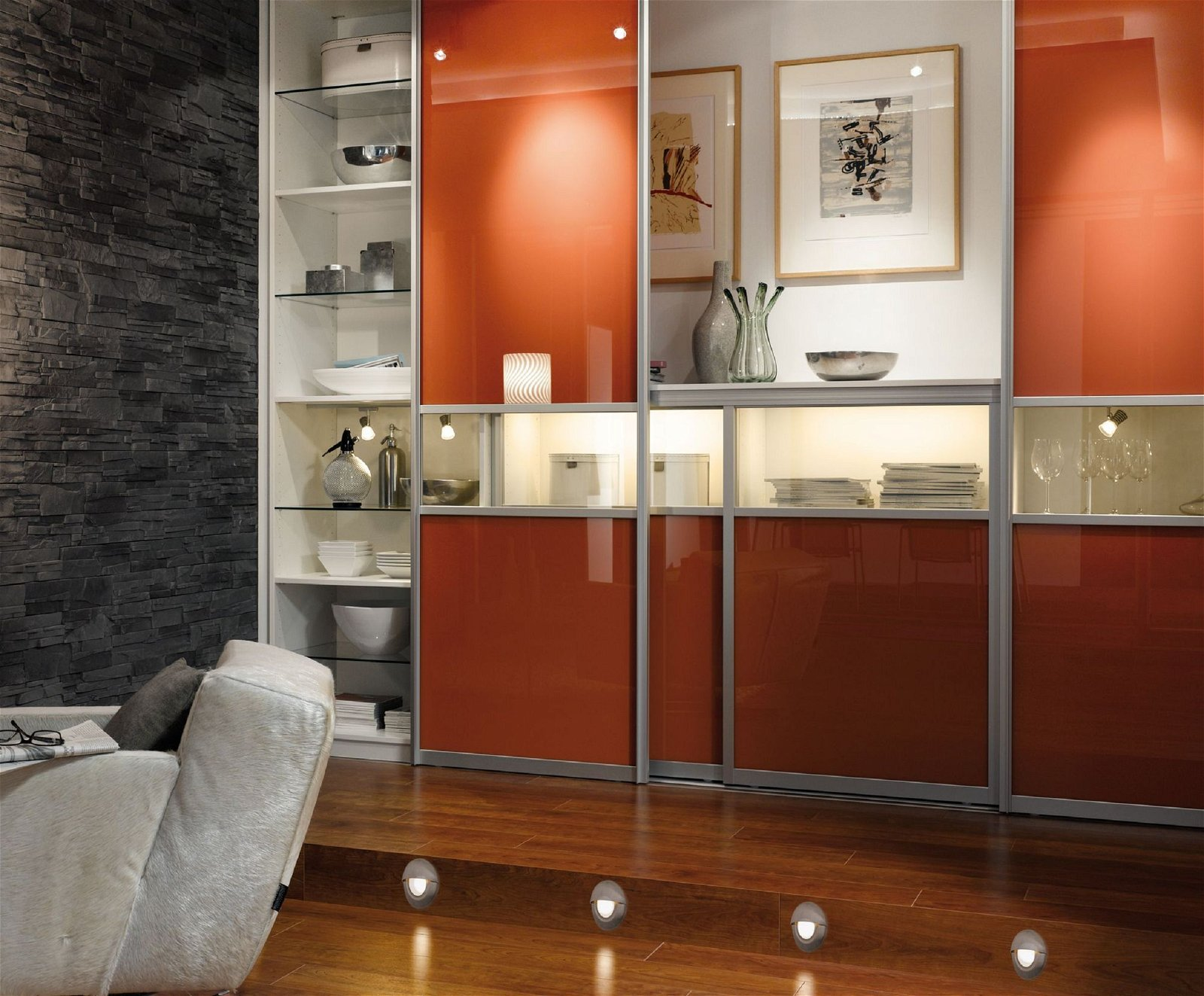 Moderne orange-weiße Wandschränke mit Lichtern, Holzboden und Couch.