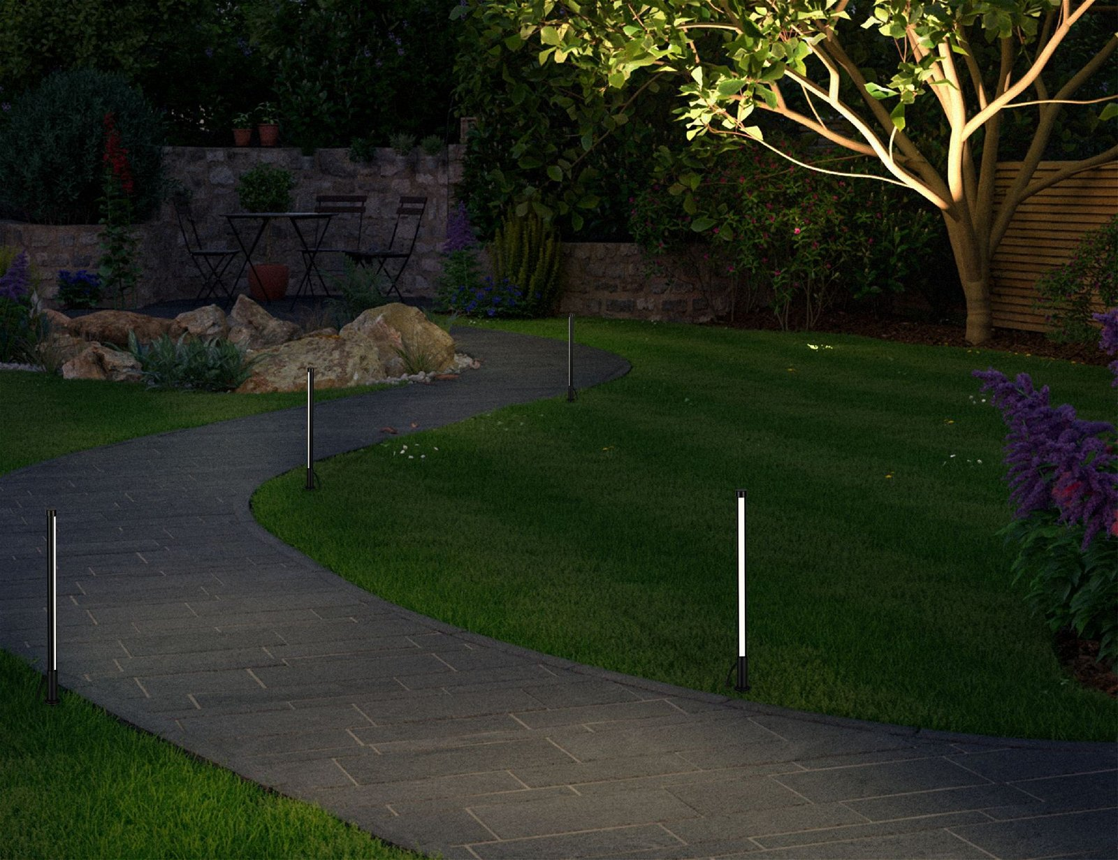 Ein Gartenweg mit Lichtern, mit Rasen, Büschen und einem Baum am Ende.