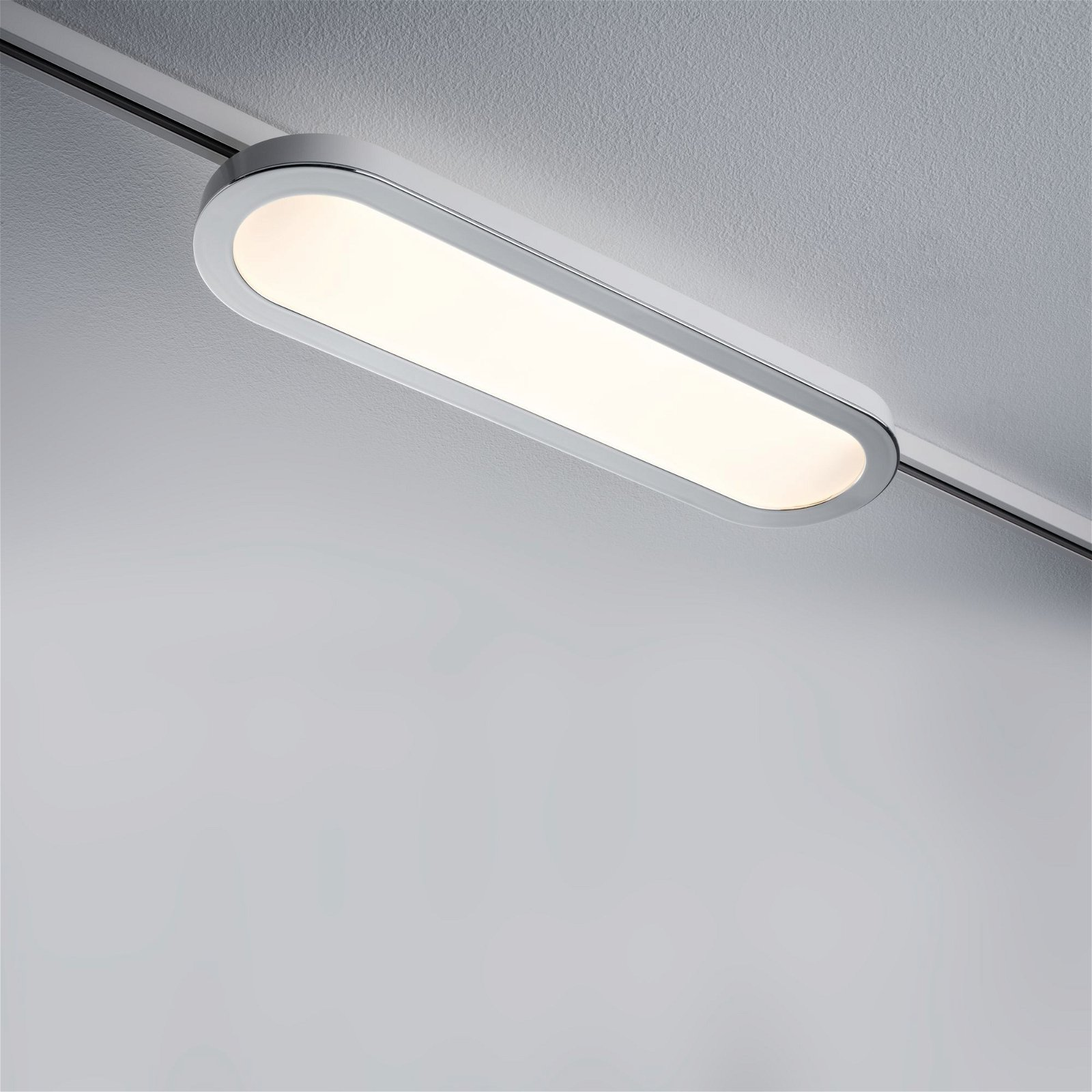 Apparecchio di illuminazione lungo, a forma ovale. Montato su binario.