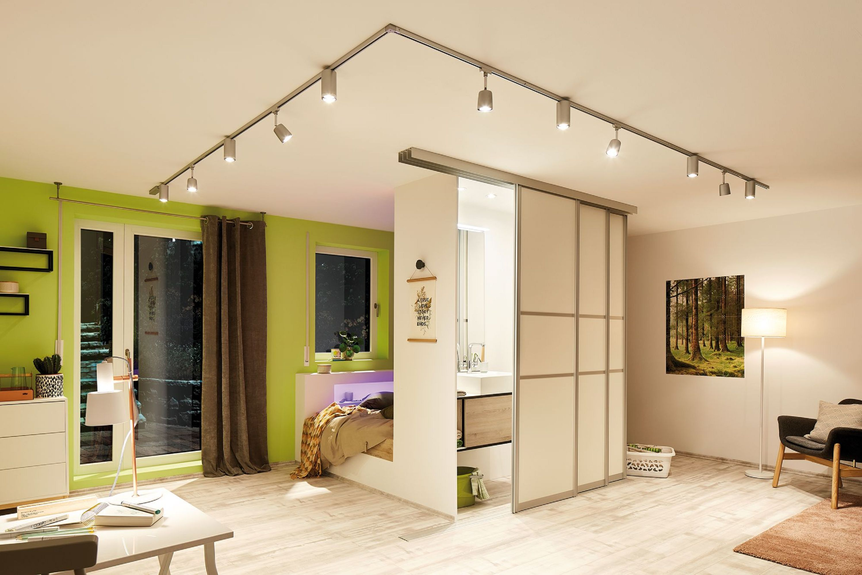 Nowoczesny pokój z łóżkiem, łazienką i systemem oświetlenia szynowego na suficie.