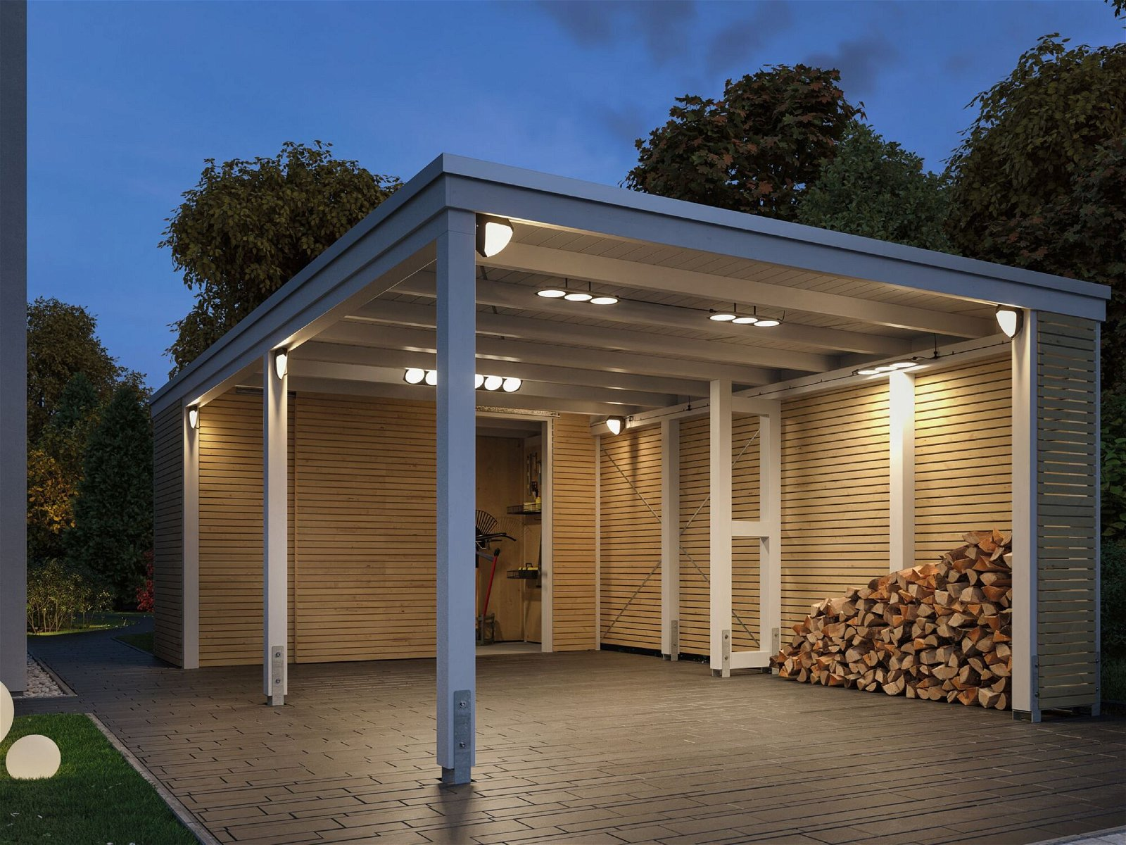 Carport mit Holzwänden und Dach, beleuchtet bei Dämmerung, Holzstapel.