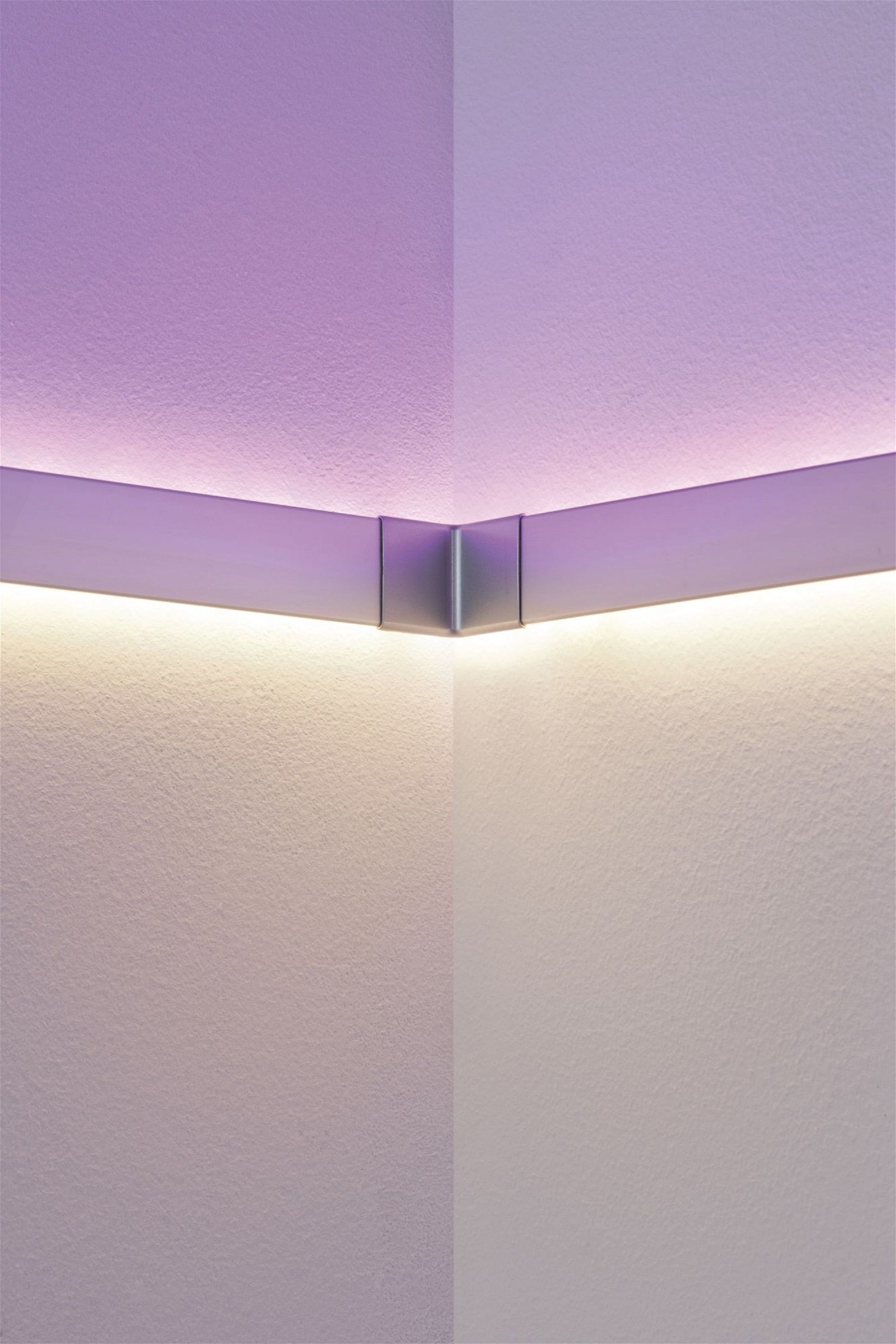 Ecke weißer Wände mit einer silbernen Lichtinstallation.