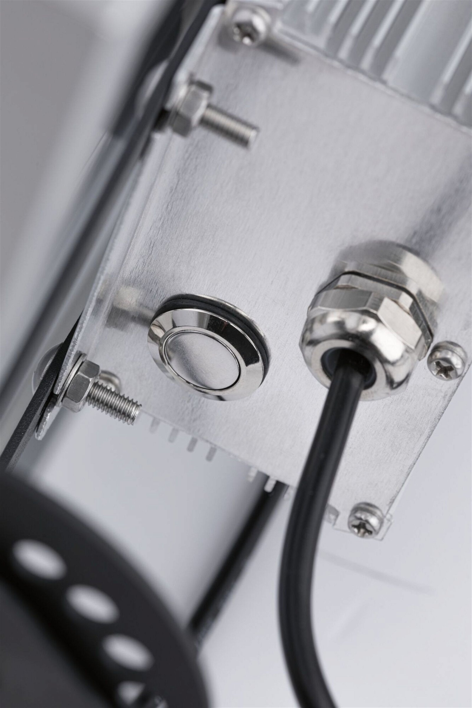 Nahaufnahme einer Metallkomponente mit Knopf und Kabel.
