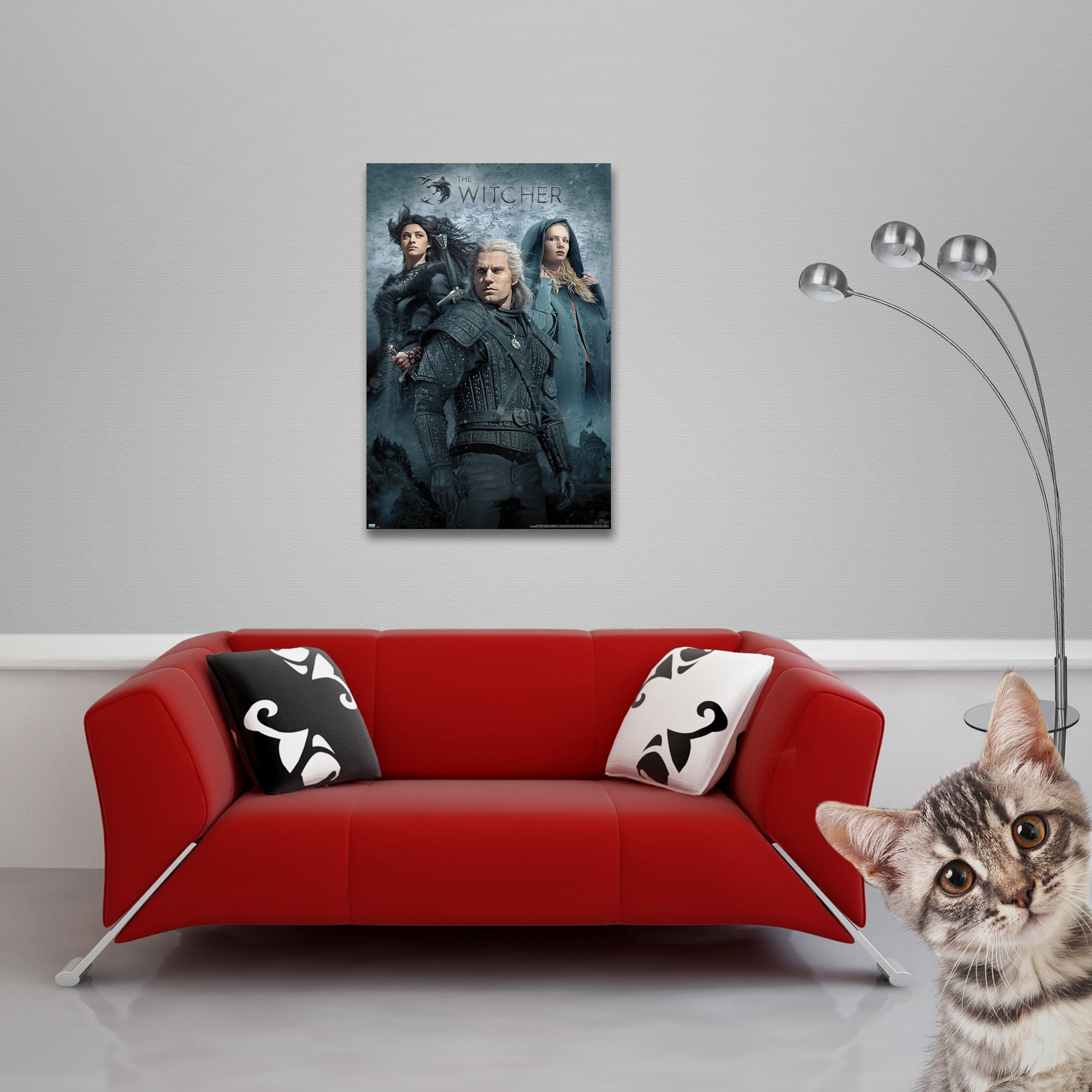 Ein Poster der Serie The Witcher. Ein rotes Sofa und eine Katze sind im Vordergrund.
