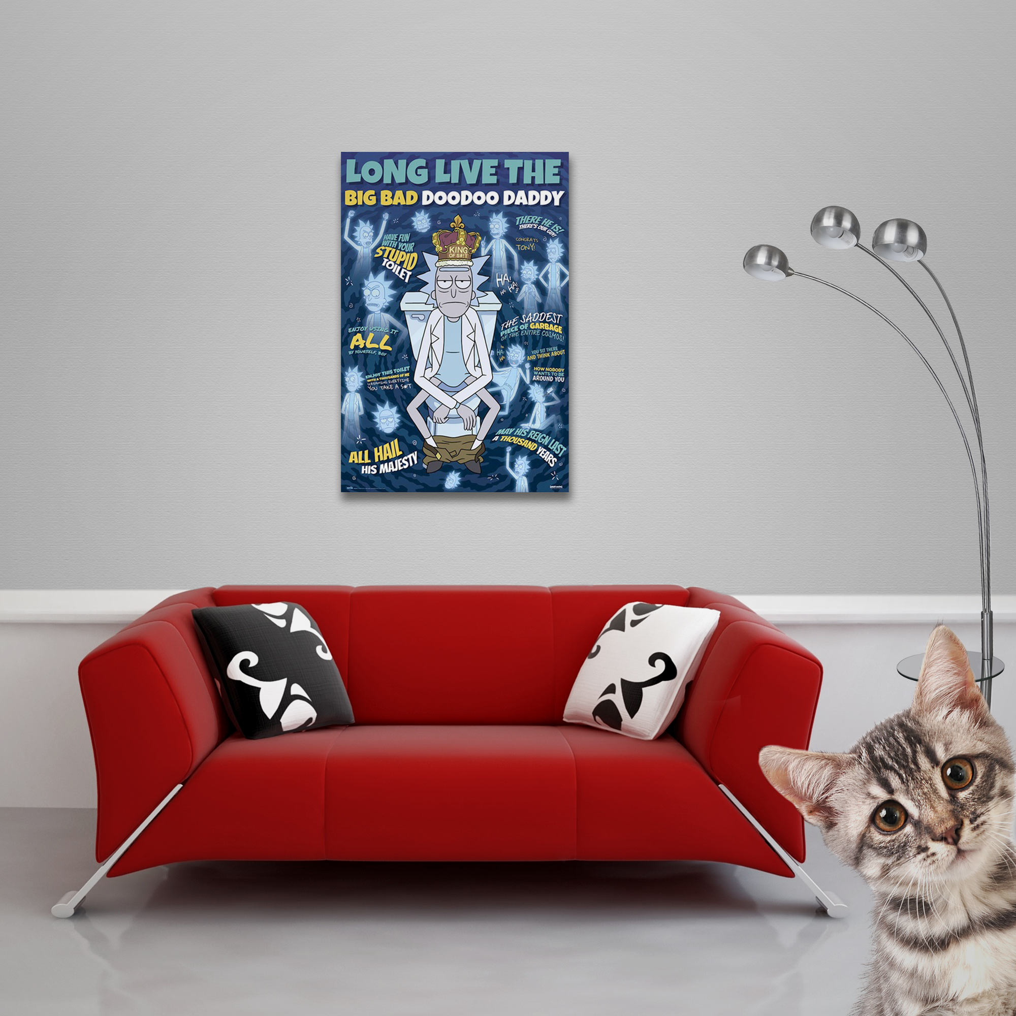 Ein Poster hängt über einem roten Sofa, mit einem Kätzchen im Vordergrund.