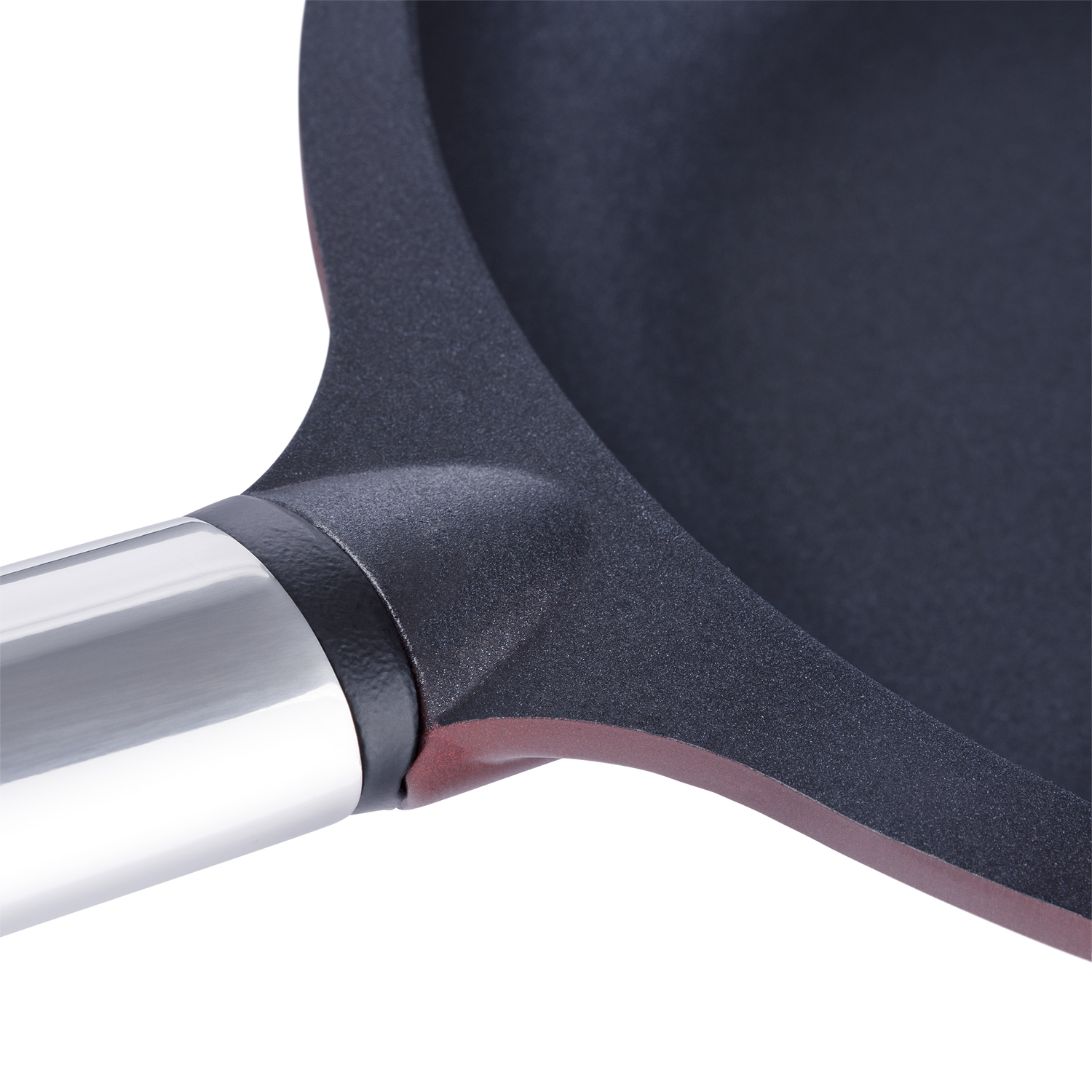 Primer plano del mango y borde de una sartén antiadherente, interior negro, borde rojo.