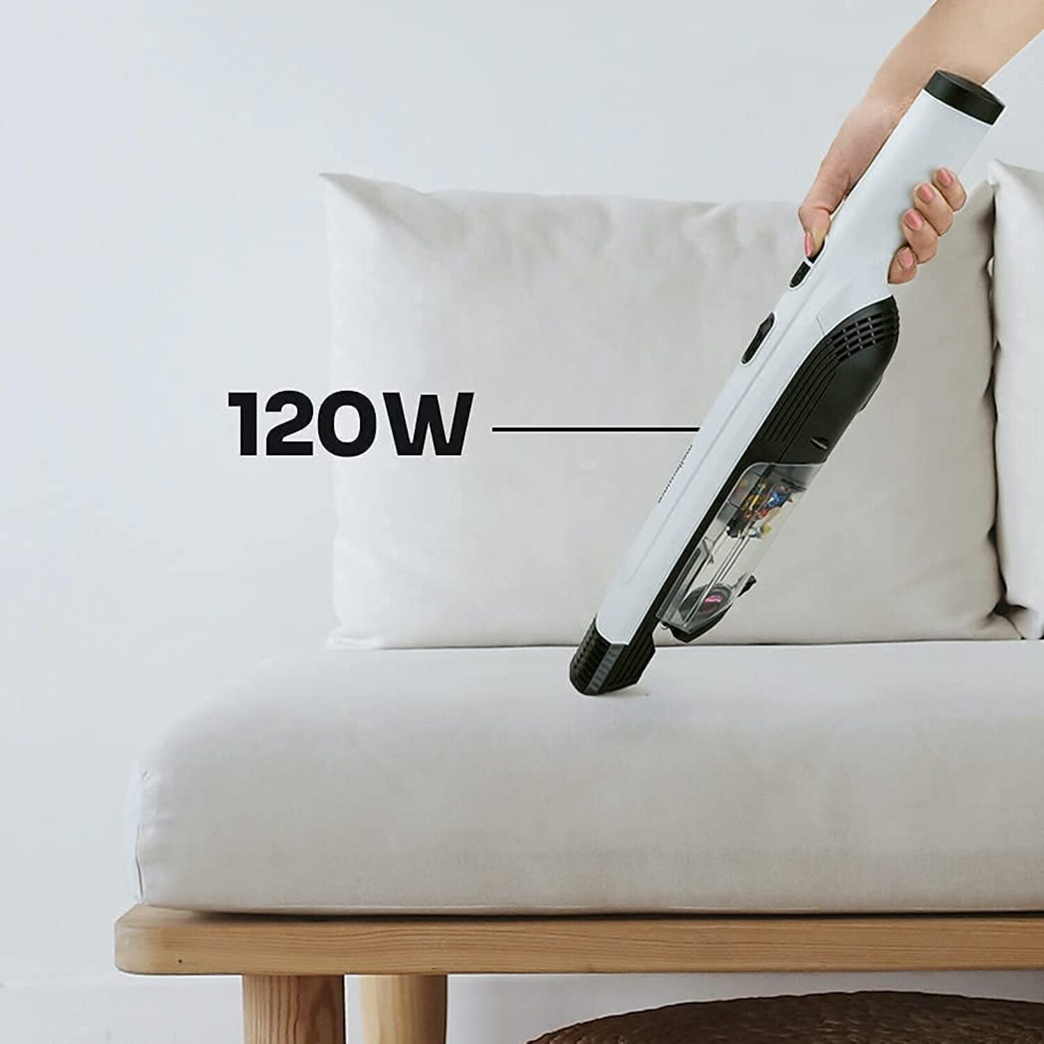 Aspirapolvere portatile senza fili, bianco e nero, vicino a un divano bianco, con la scritta 120W.