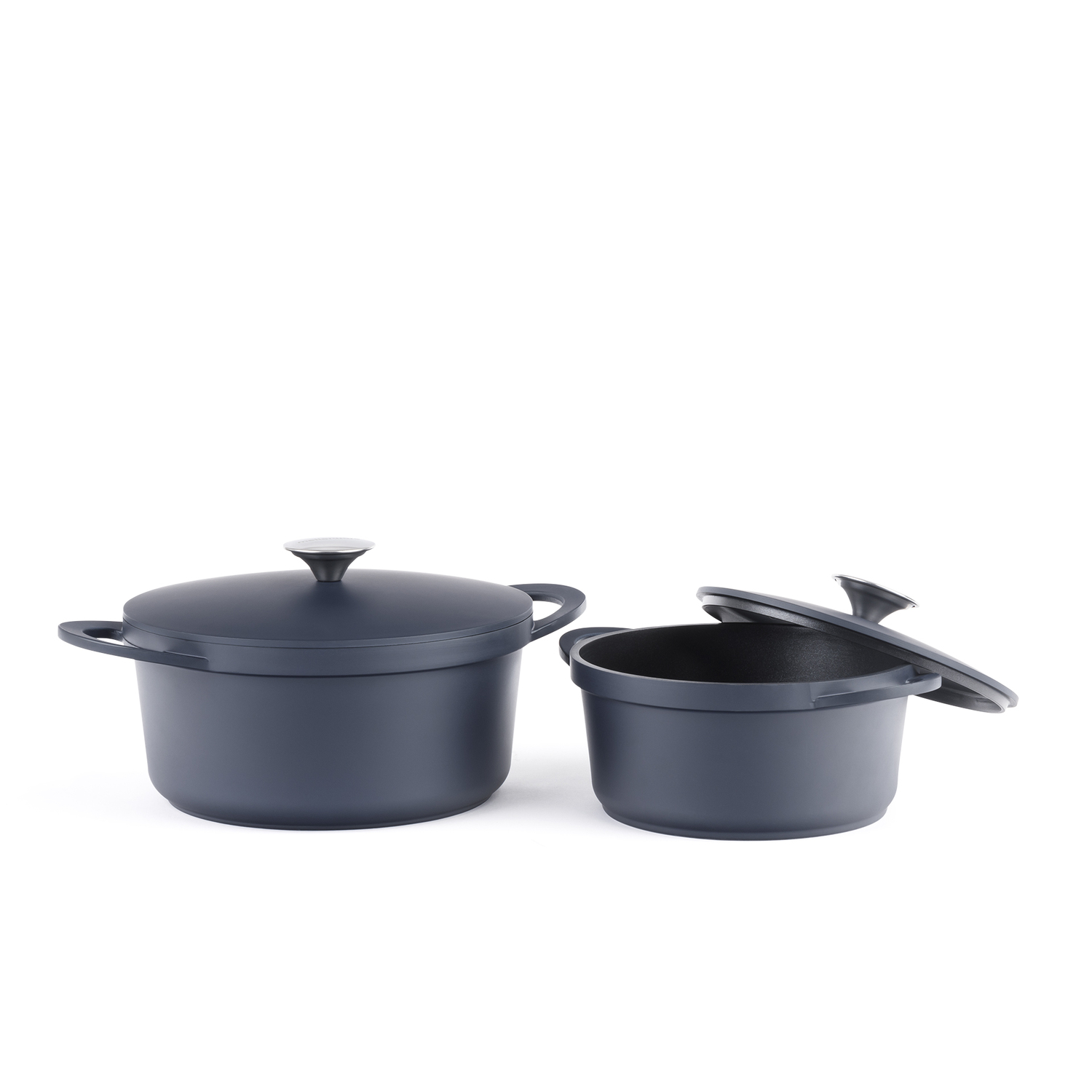 Dos ollas de cocina azul oscuro con tapas, sobre un fondo blanco.