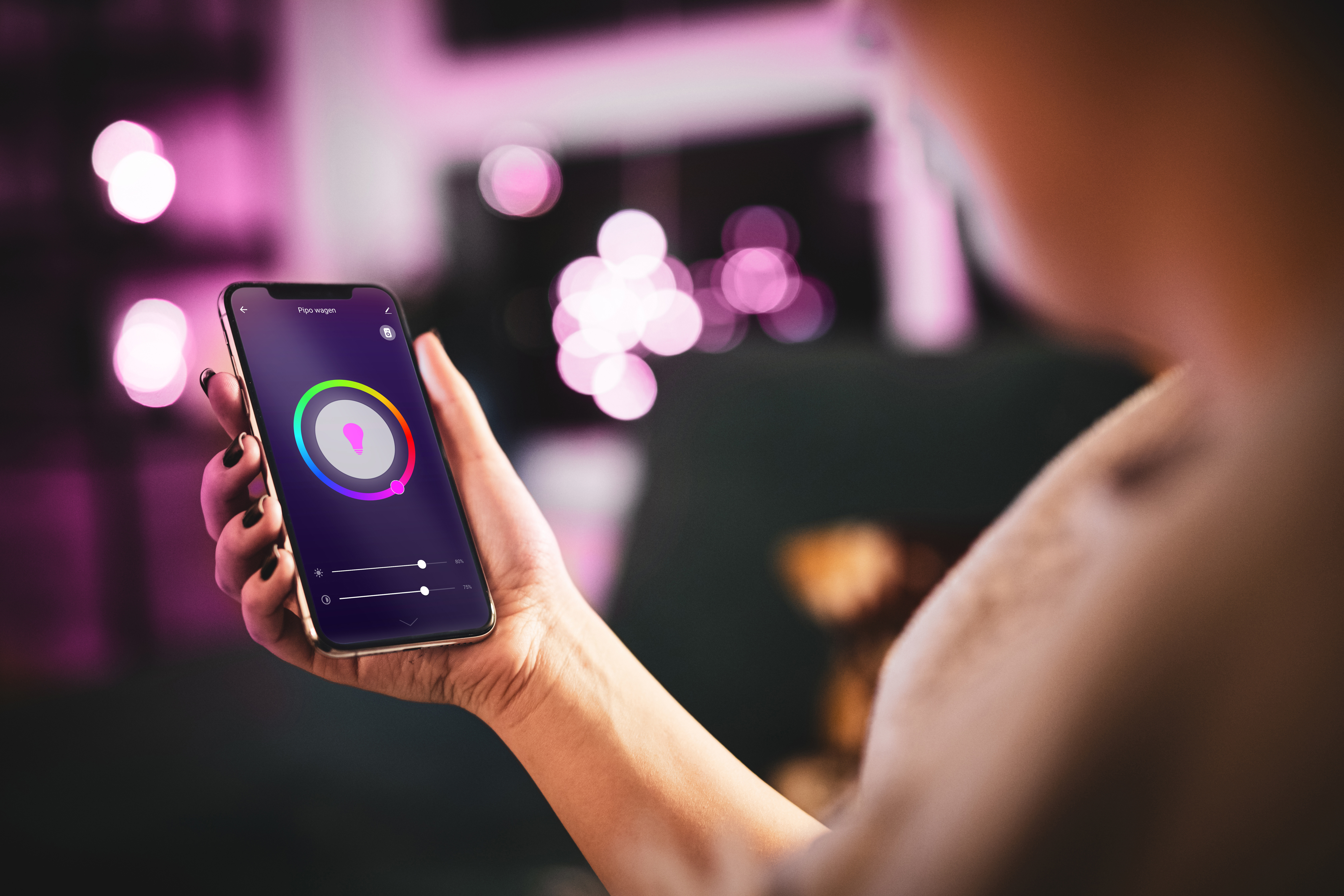 Osoba trzymająca smartfon wyświetlający interfejs aplikacji z kołem kolorów.