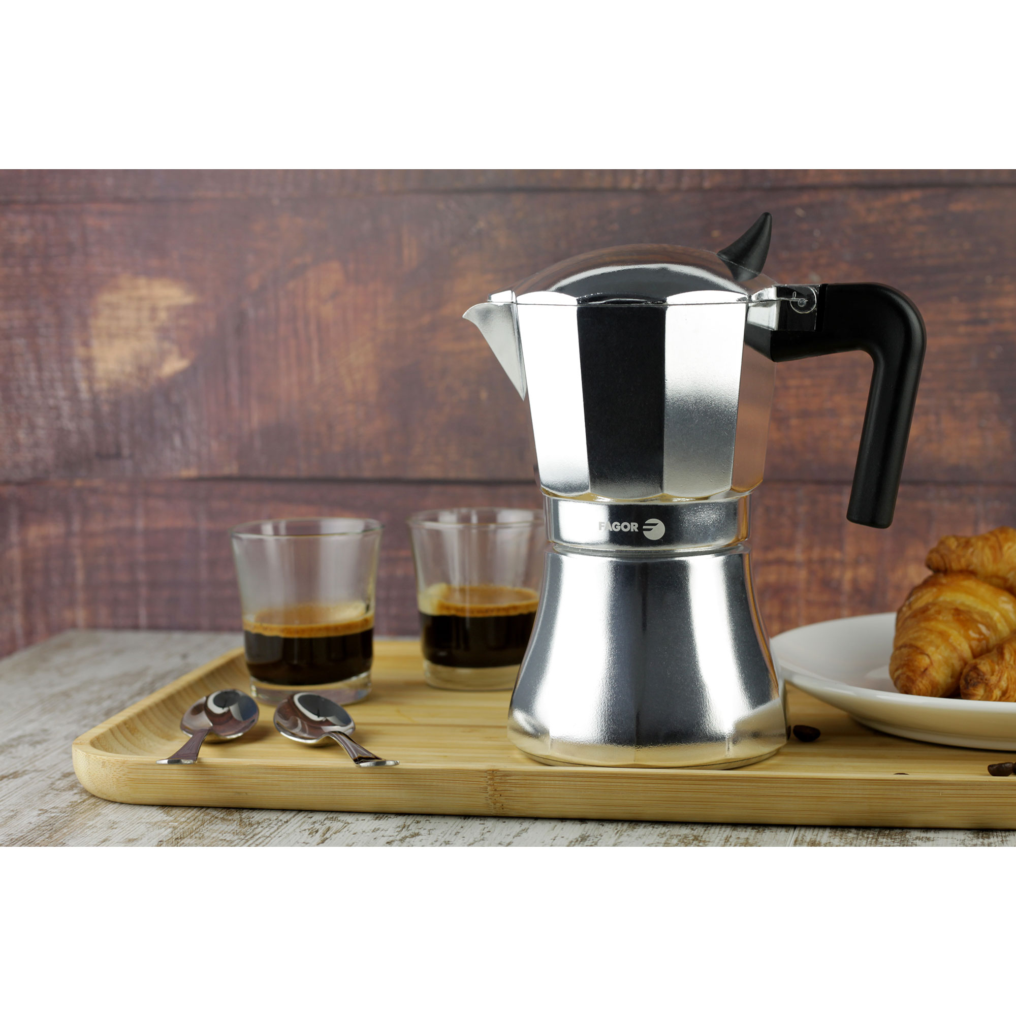 Moka, espresso in bicchieri e croissant su vassoio di legno, sfondo in legno.