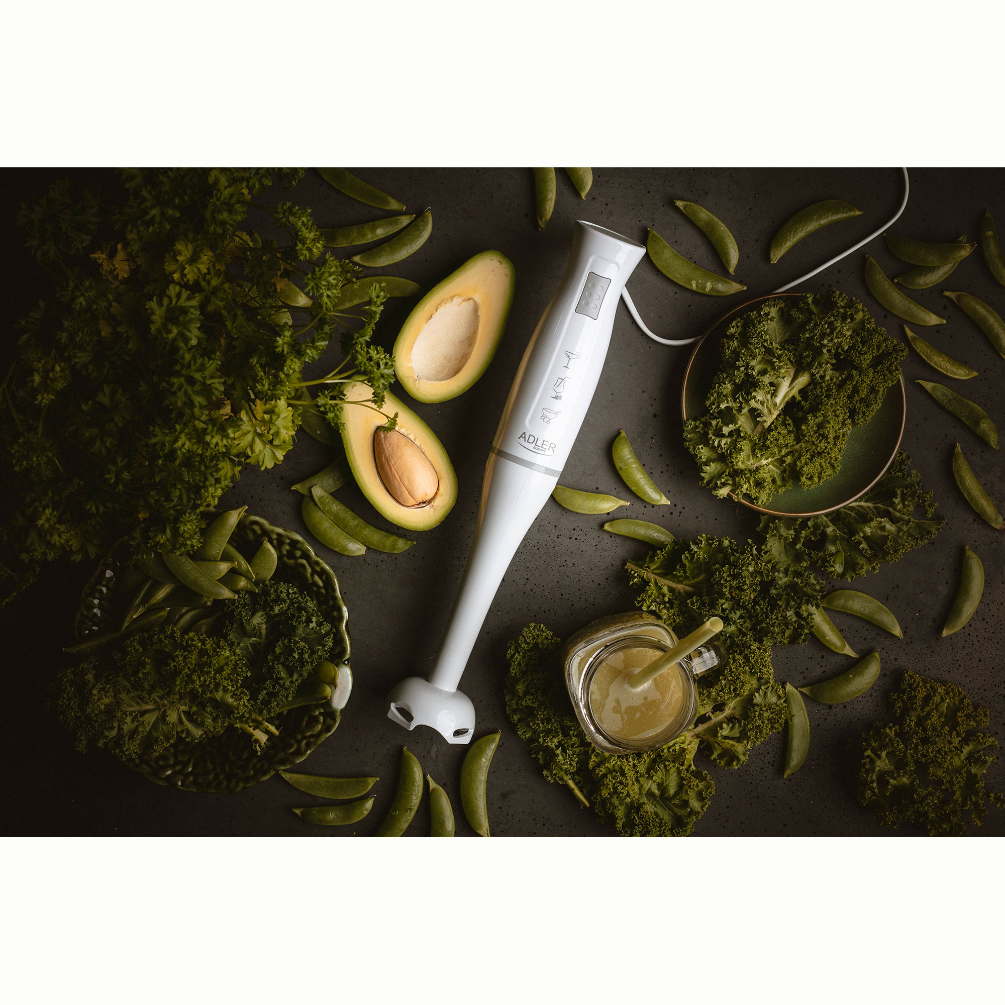 Witte blender met avocado en erwten op een donkere ondergrond. Groene smoothie in glas.