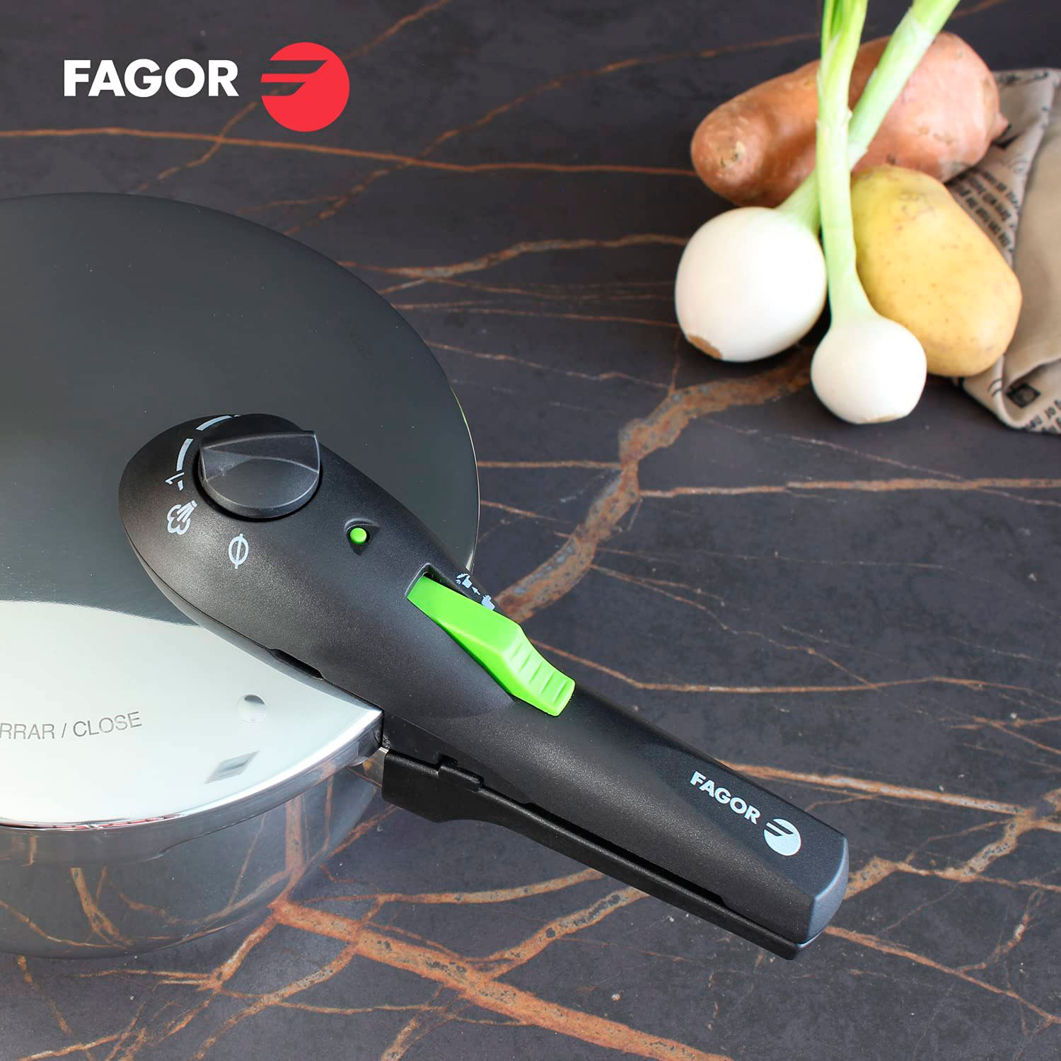 Olla a presión negra con asa negra y verde, con verduras en el fondo.