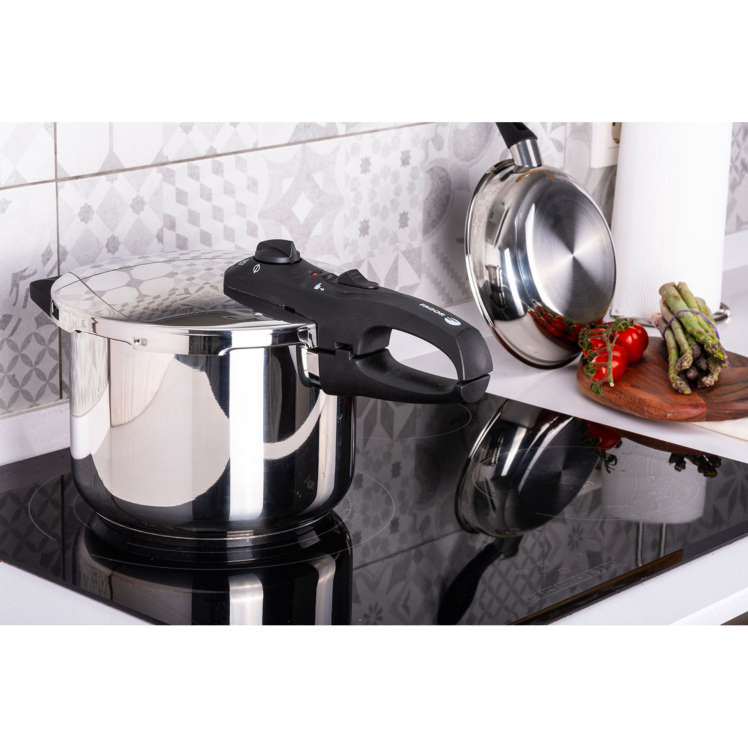 Olla a presión en estufa con verduras y sartén.