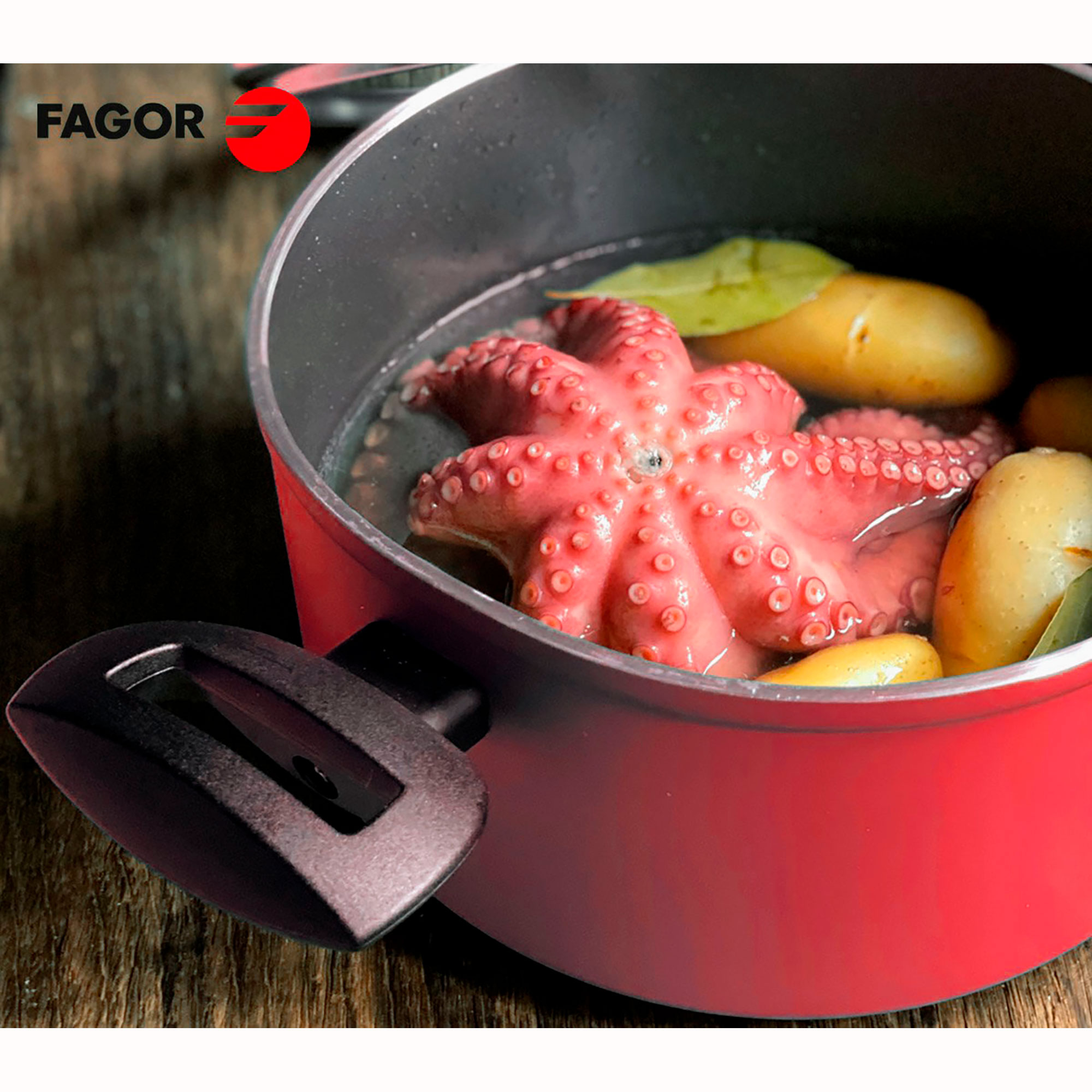 Una olla de cocina roja con un pulpo dentro, sumergido en líquido de cocción con hojas de laurel, primer plano.