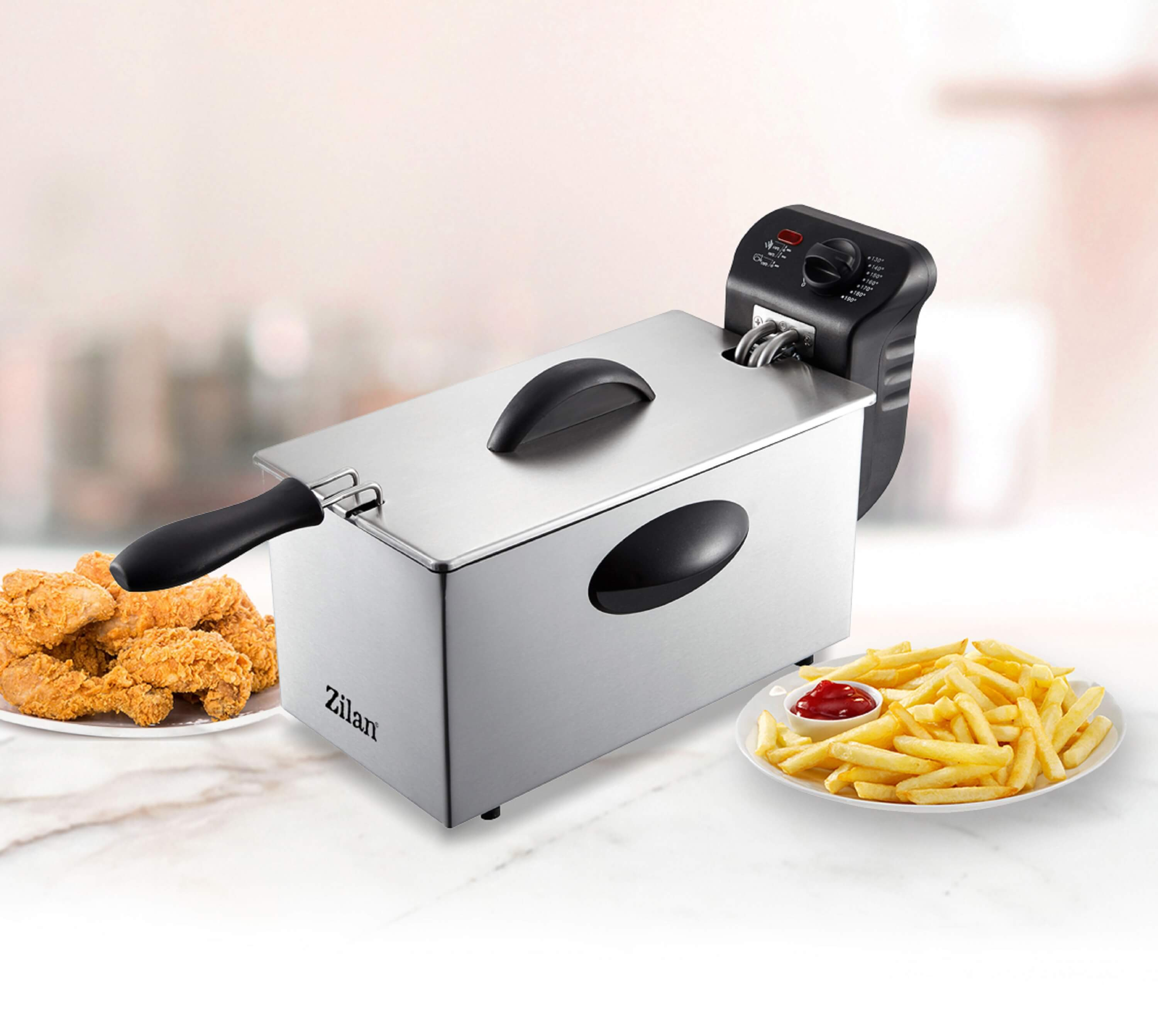 Kızarmış tavuk ve patates kızartması ile paslanmaz çelik fritöz, yanında bir tabakta ketçap.
