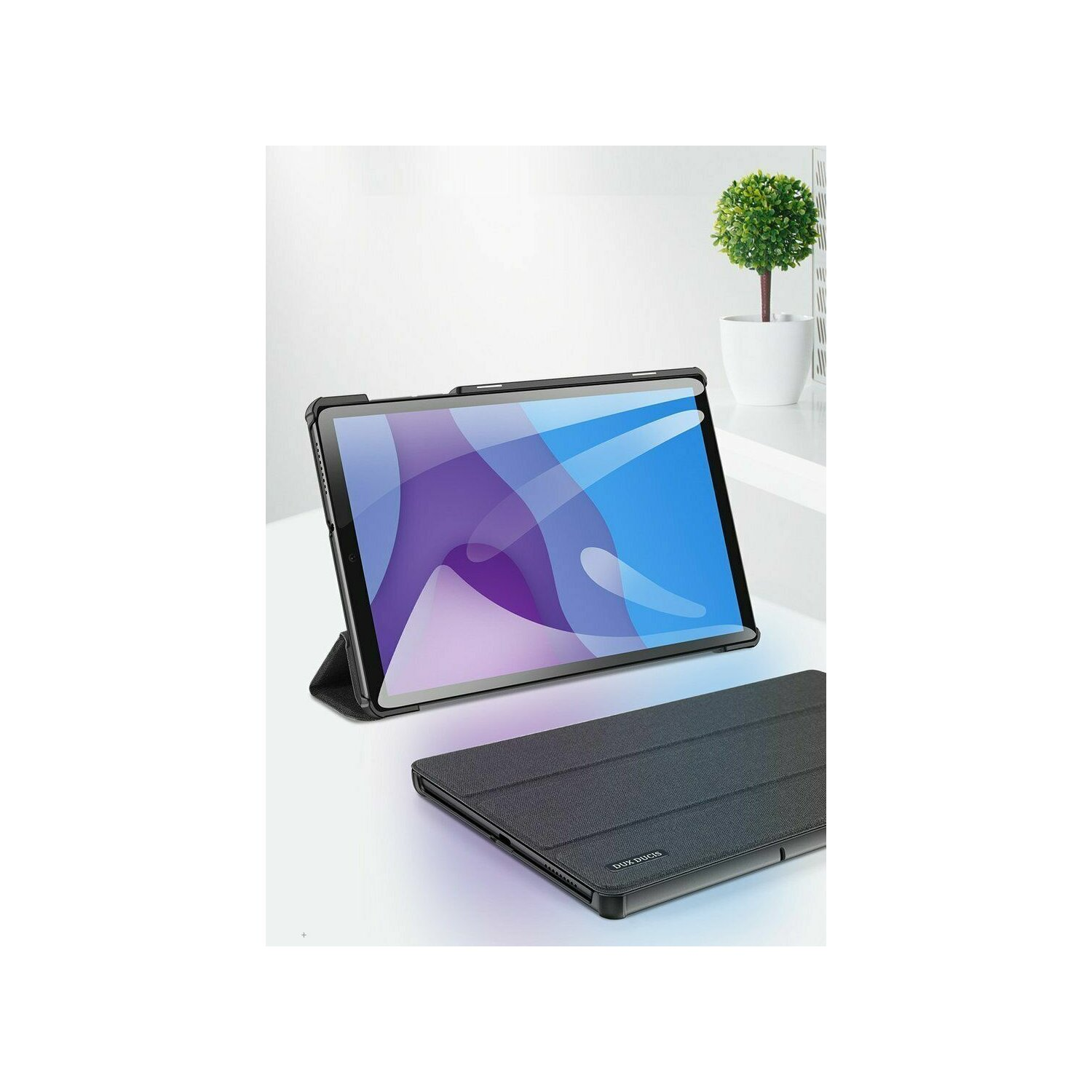 Ein Tablet mit Hülle auf weißer Oberfläche, mit einer kleinen Pflanze im Hintergrund.