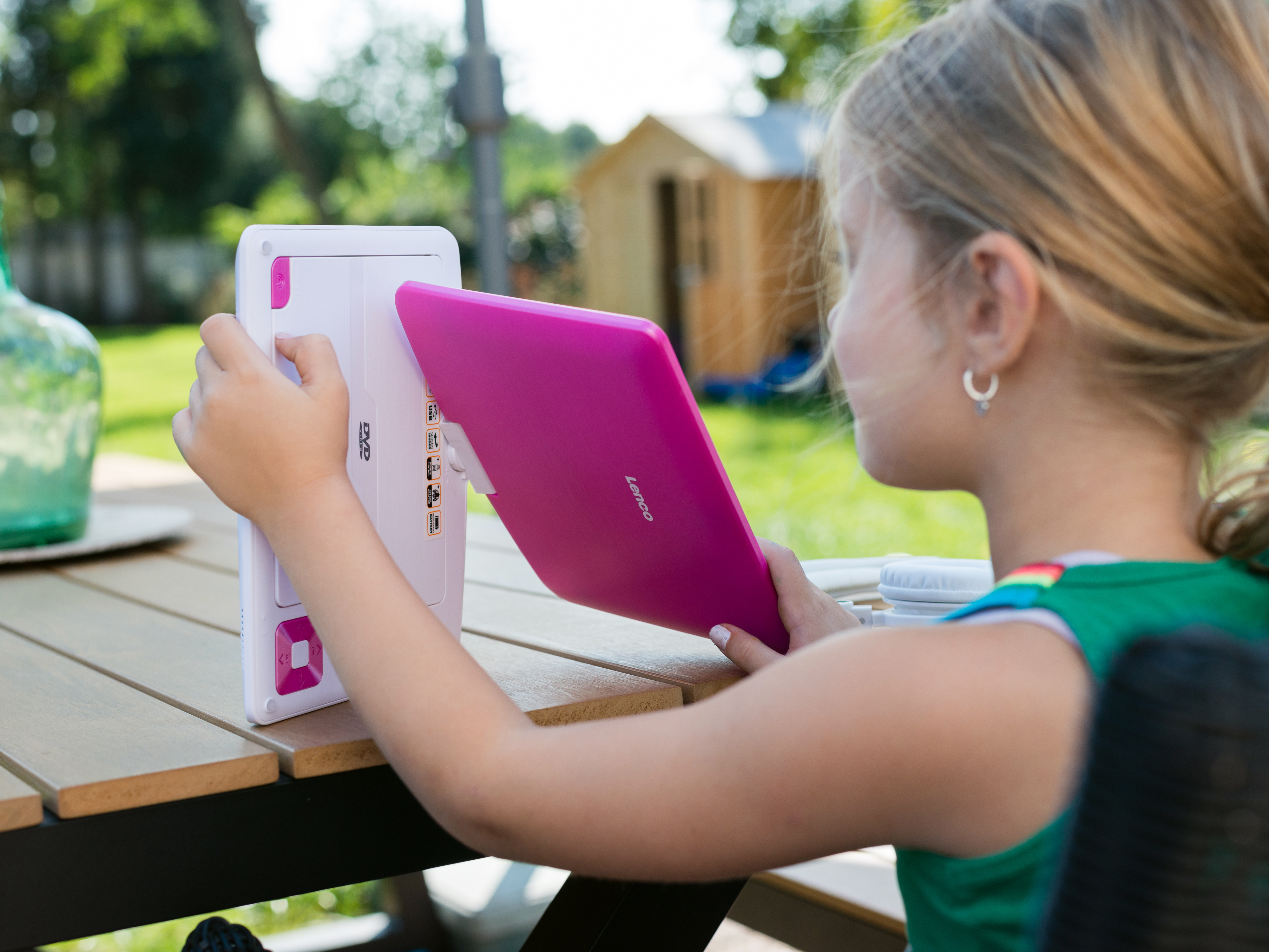 Dziewczyna trzymająca różowy tablet z białą obudową.