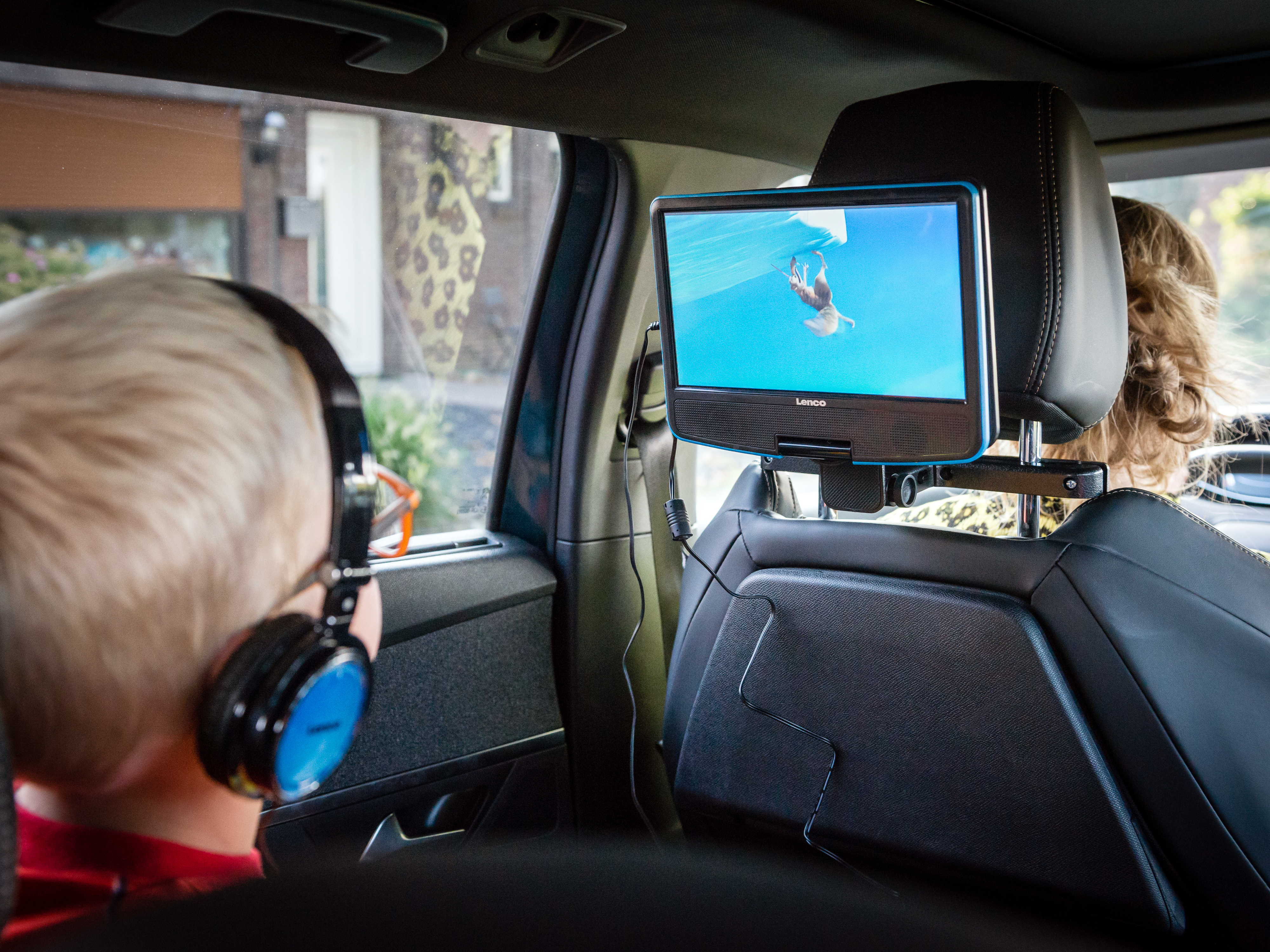 Turkusowy kosz na śmieci z pokrywą, otoczony drewnianymi ramami i niebieskim pociągnięciem.