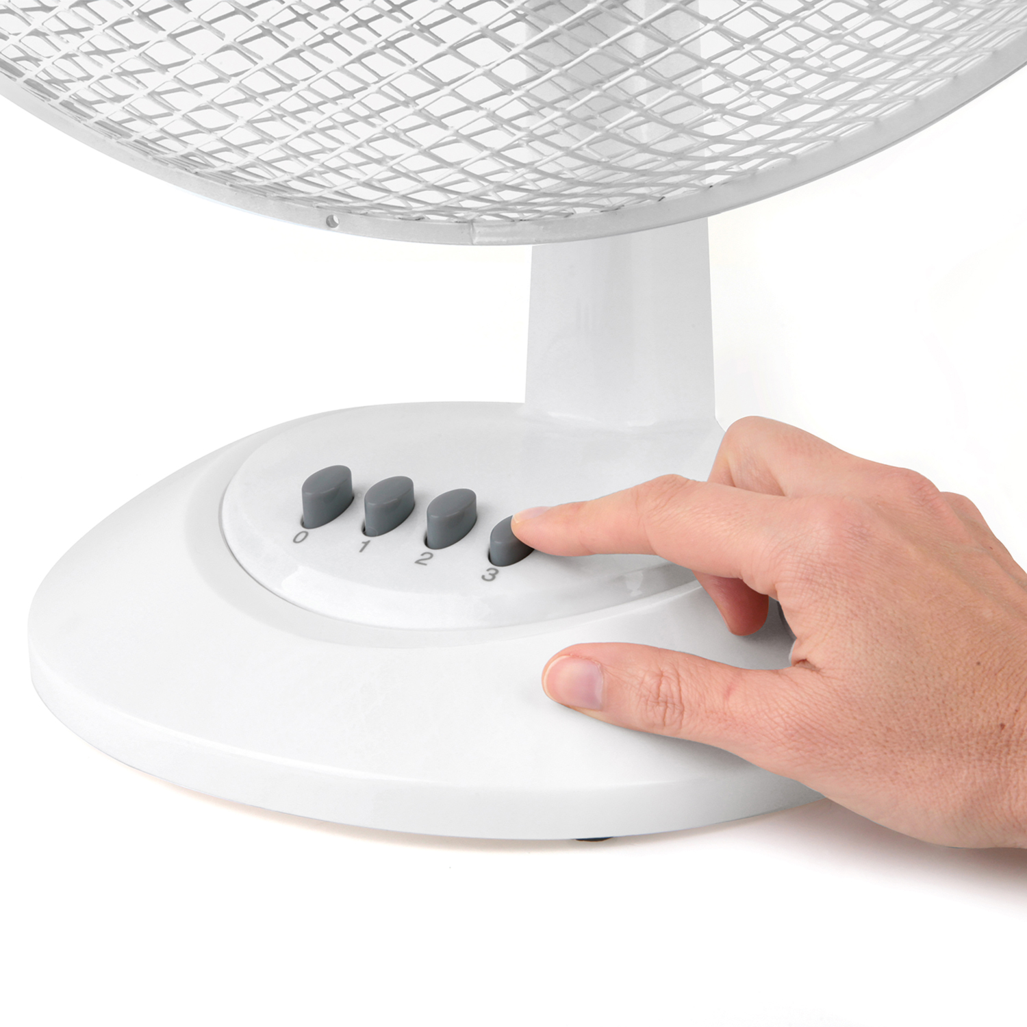 Una mano preme un pulsante su un ventilatore bianco, con tre pulsanti etichettati 0, 1, 2 e 3, su uno sfondo bianco.