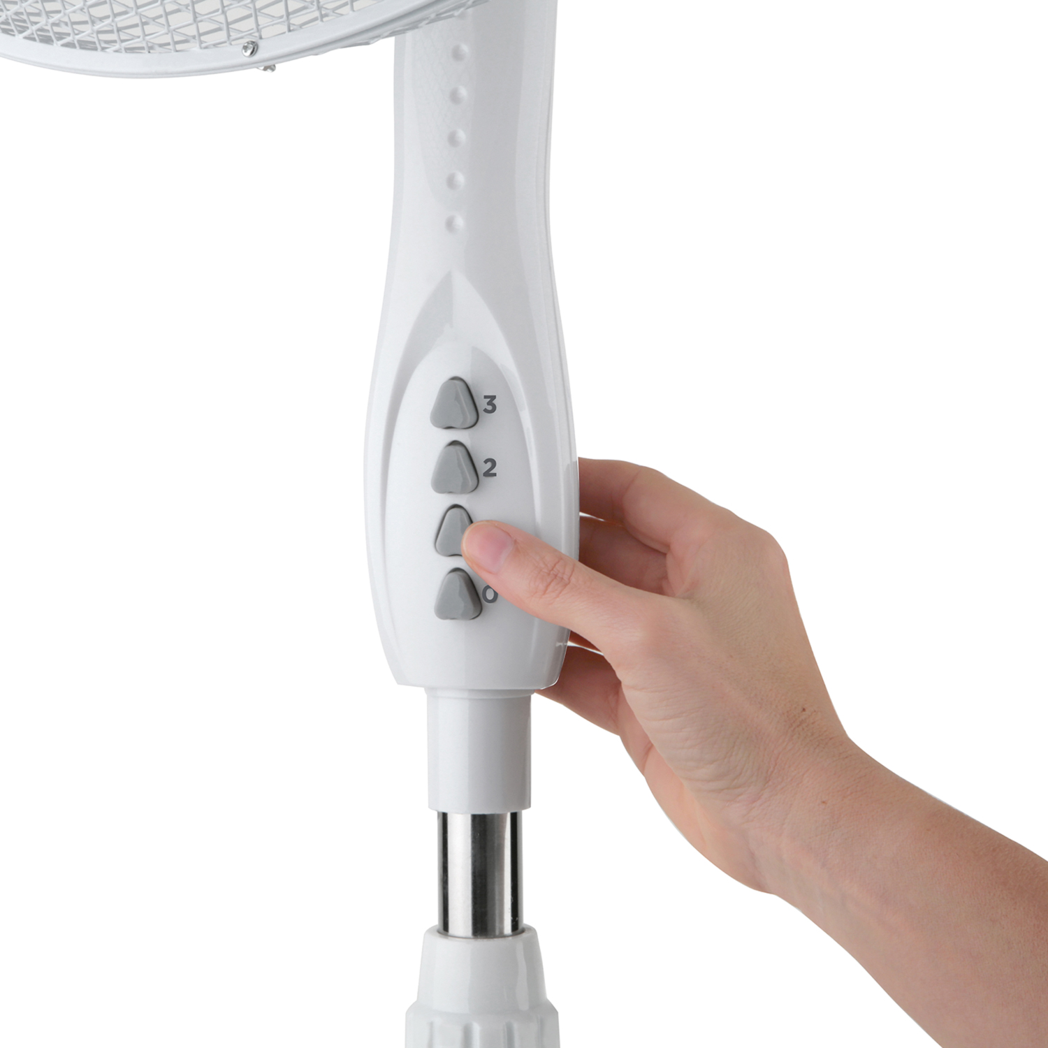 Una mano preme un pulsante sul pannello di controllo di un ventilatore a colonna bianco.