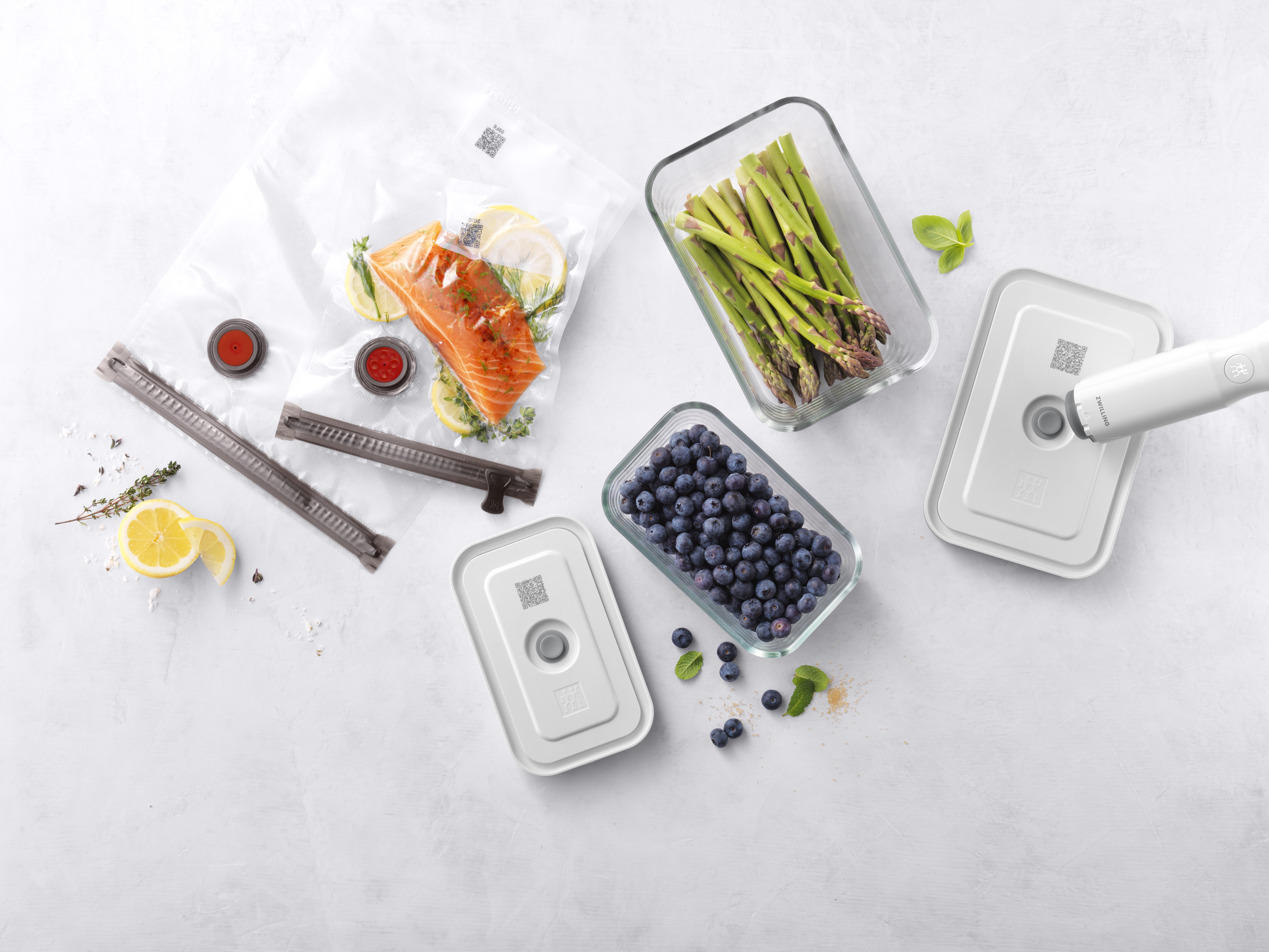 Produkty spożywcze: łosoś, szparagi i borówki w szklanych pojemnikach, z pakowarką.