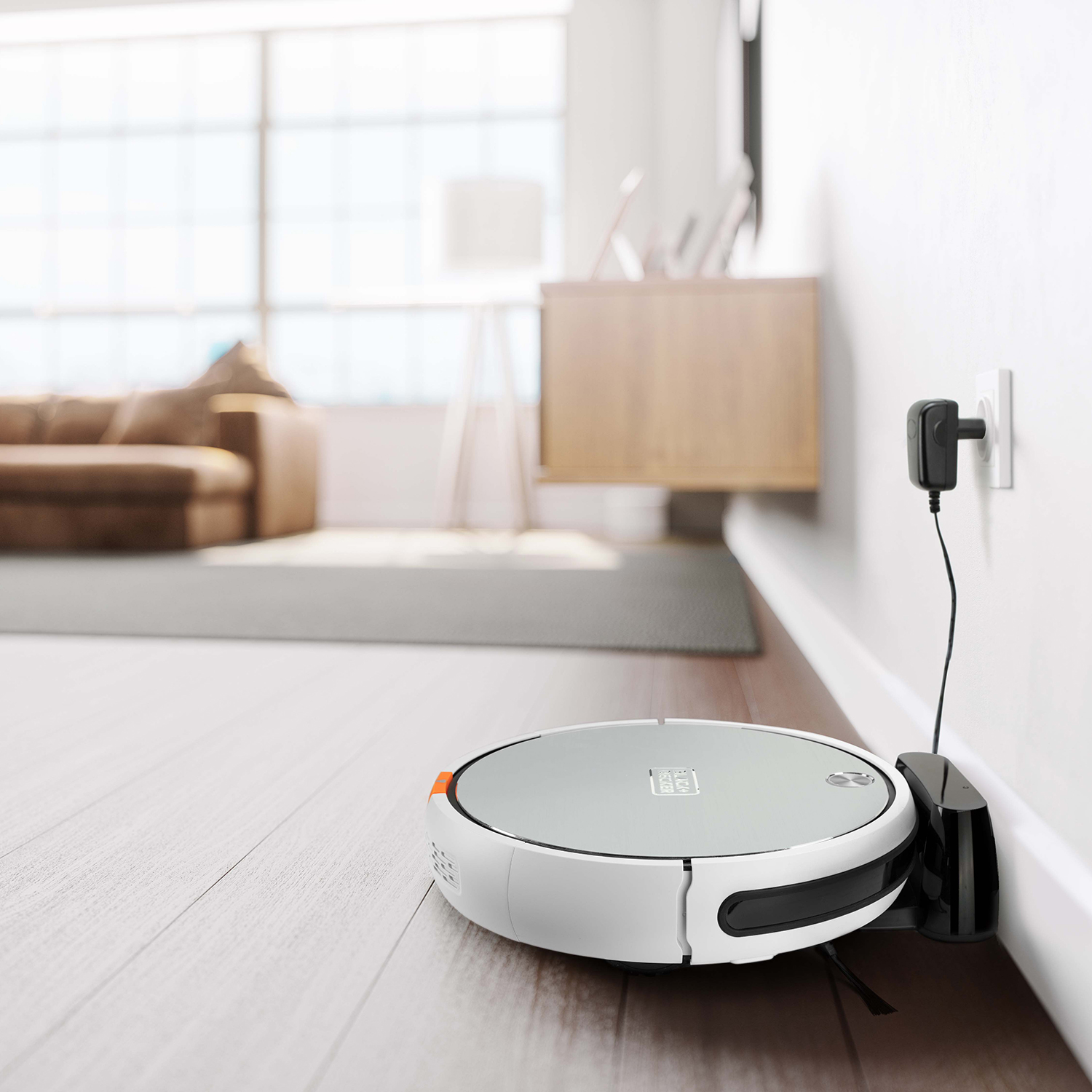 Odkurzacz robot na drewnianej podłodze, stacja ładująca na ścianie. Tło: salon z kanapą i oknem.