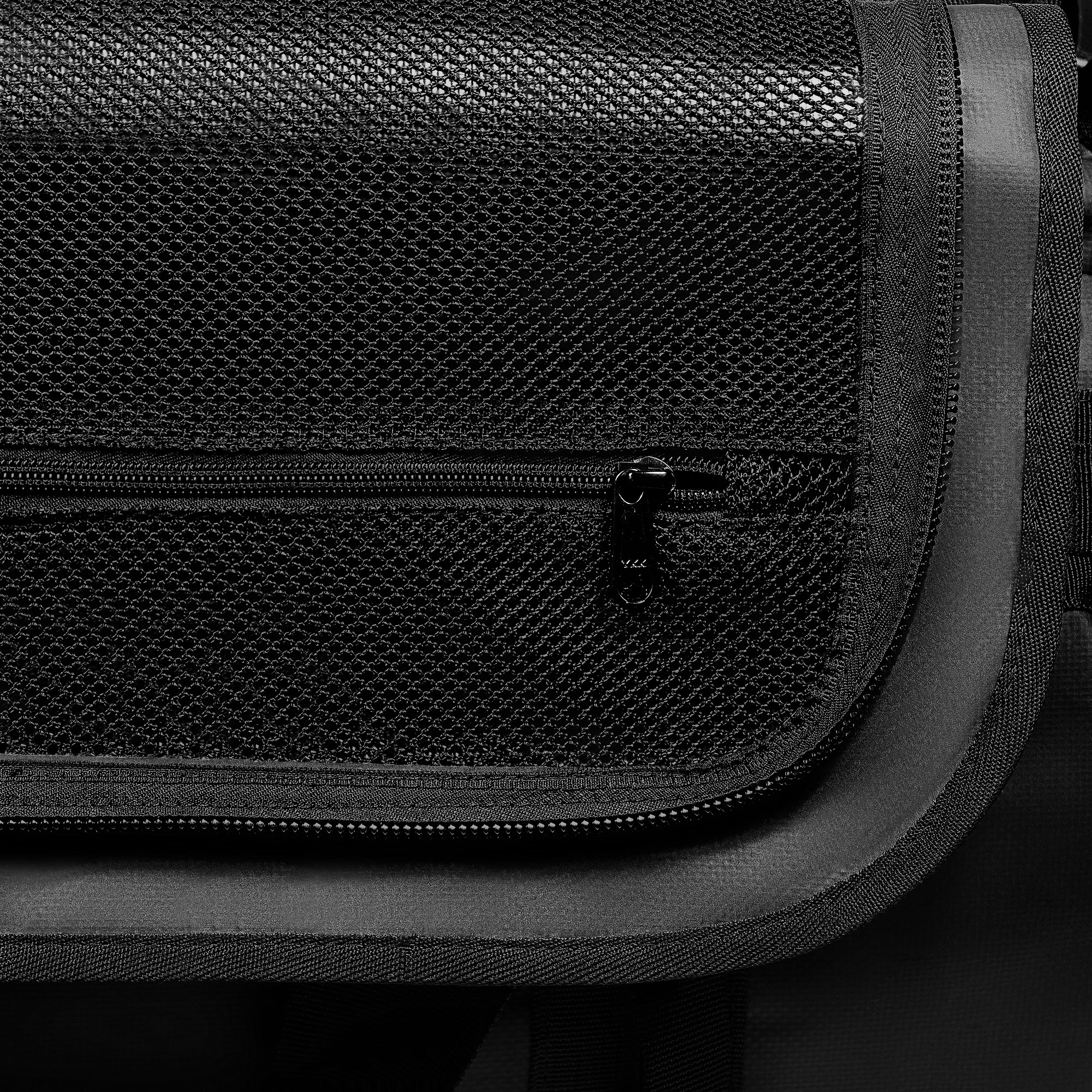 Nahaufnahme einer schwarzen Netztasche mit Reißverschluss. Die Textur des Netzes ist sichtbar.