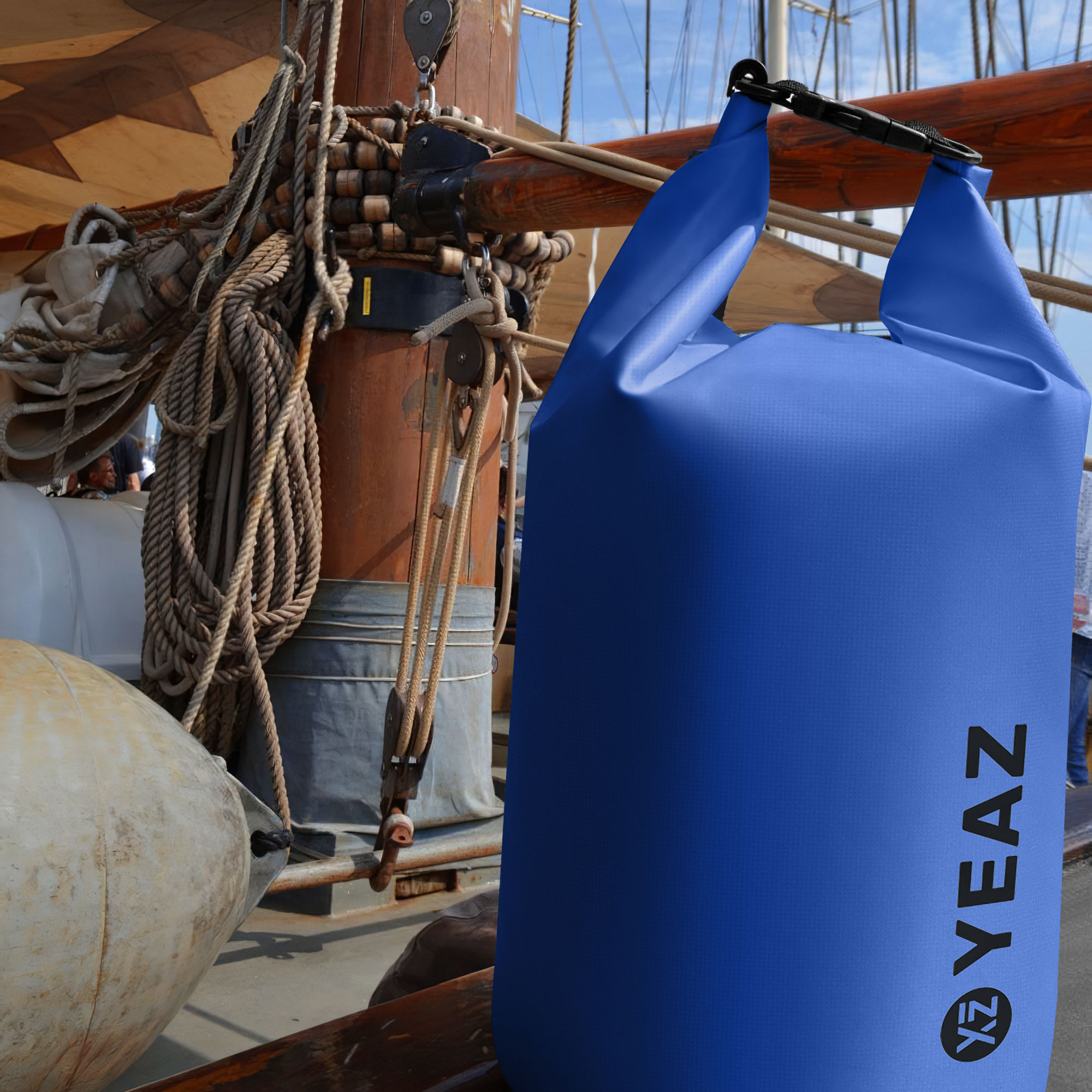 Bolsa seca turquesa colgada en un barco con cuerdas y madera.