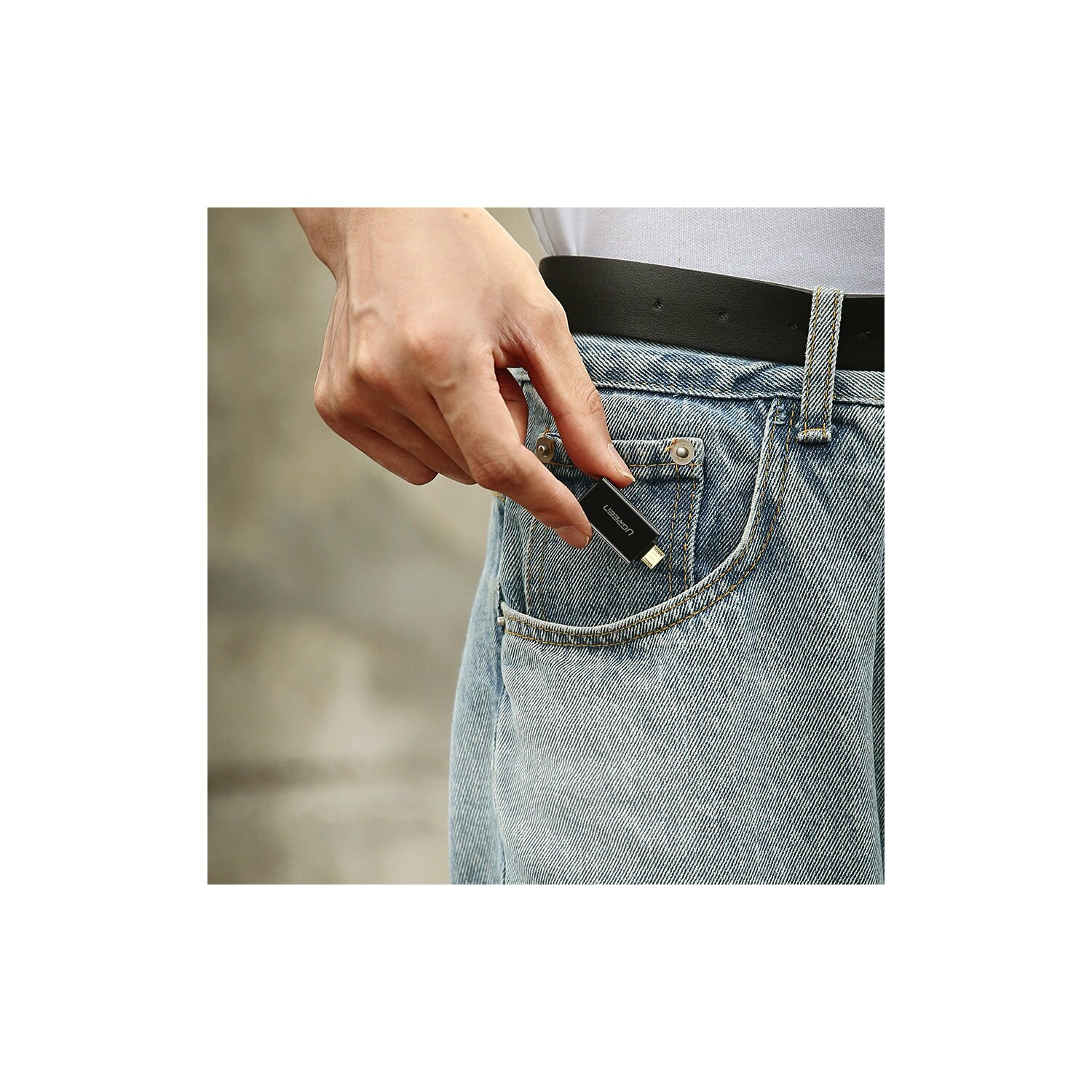 Eine Hand, die einen USB-Stick in einer Jeans-Tasche hält.