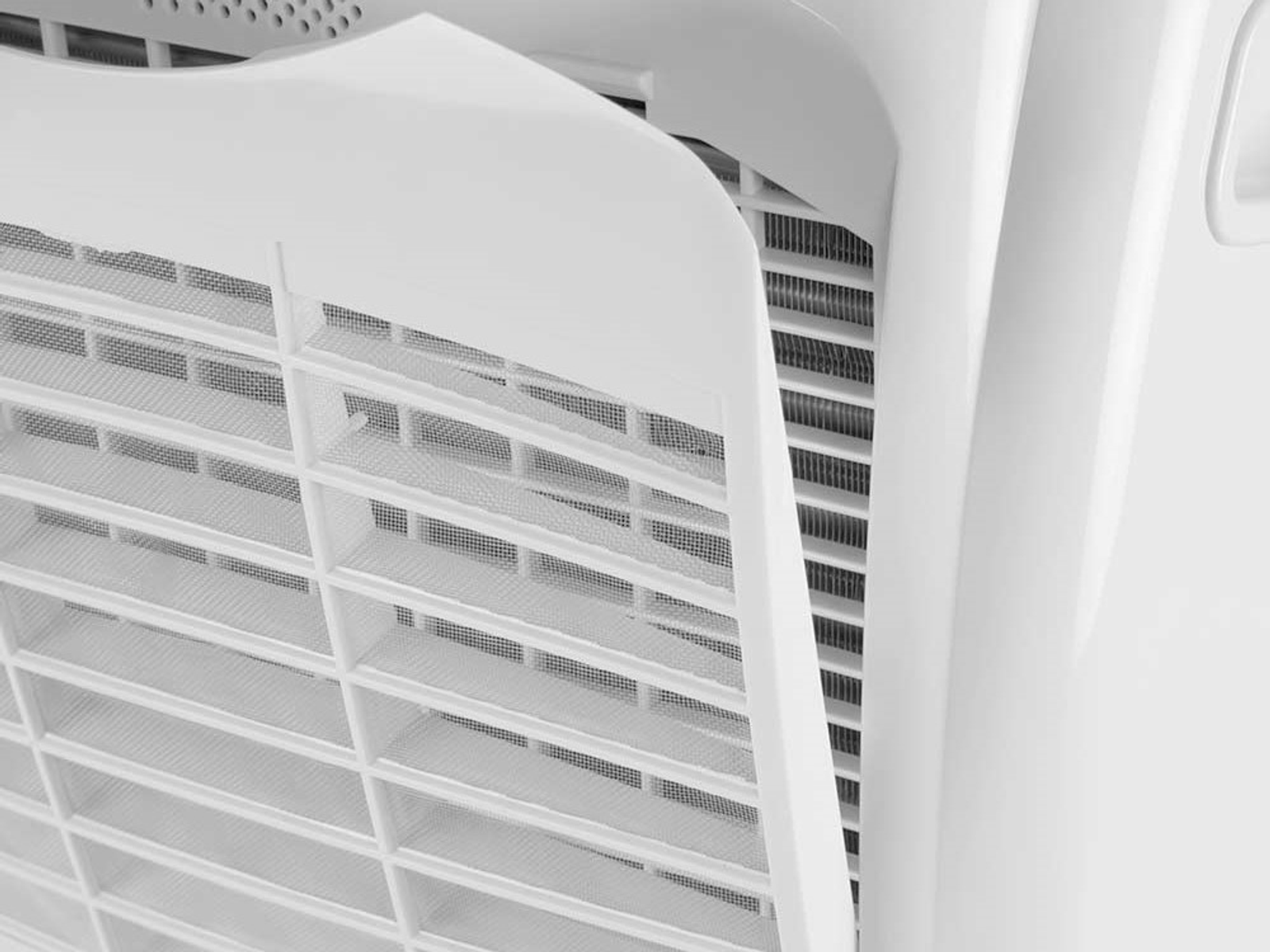 Primo piano di un filtro per purificatore d'aria bianco e una rete. Il filtro è parzialmente staccato dall'unità.