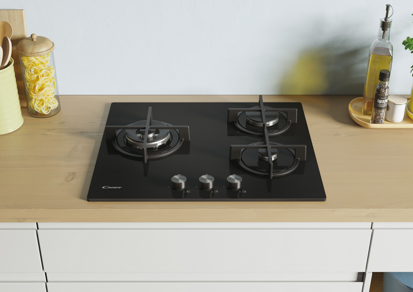 Czarna płyta grzewcza ze szkła z trzema palnikami i pokrętłami na drewnianym blacie.