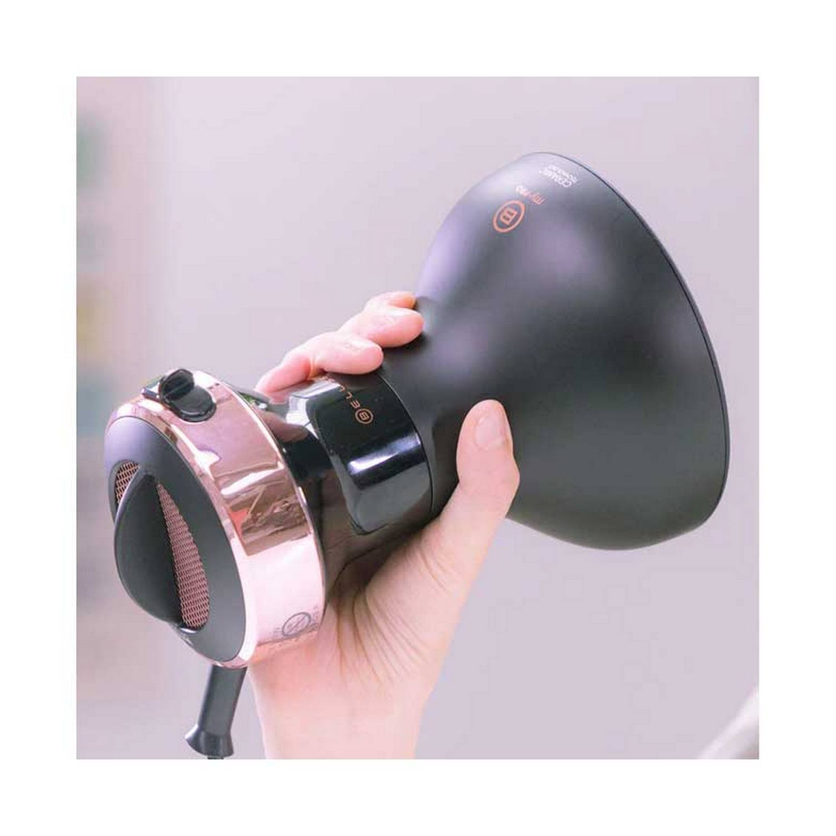 Dłoń trzyma czarną i różowo-złotą suszarkę do włosów.