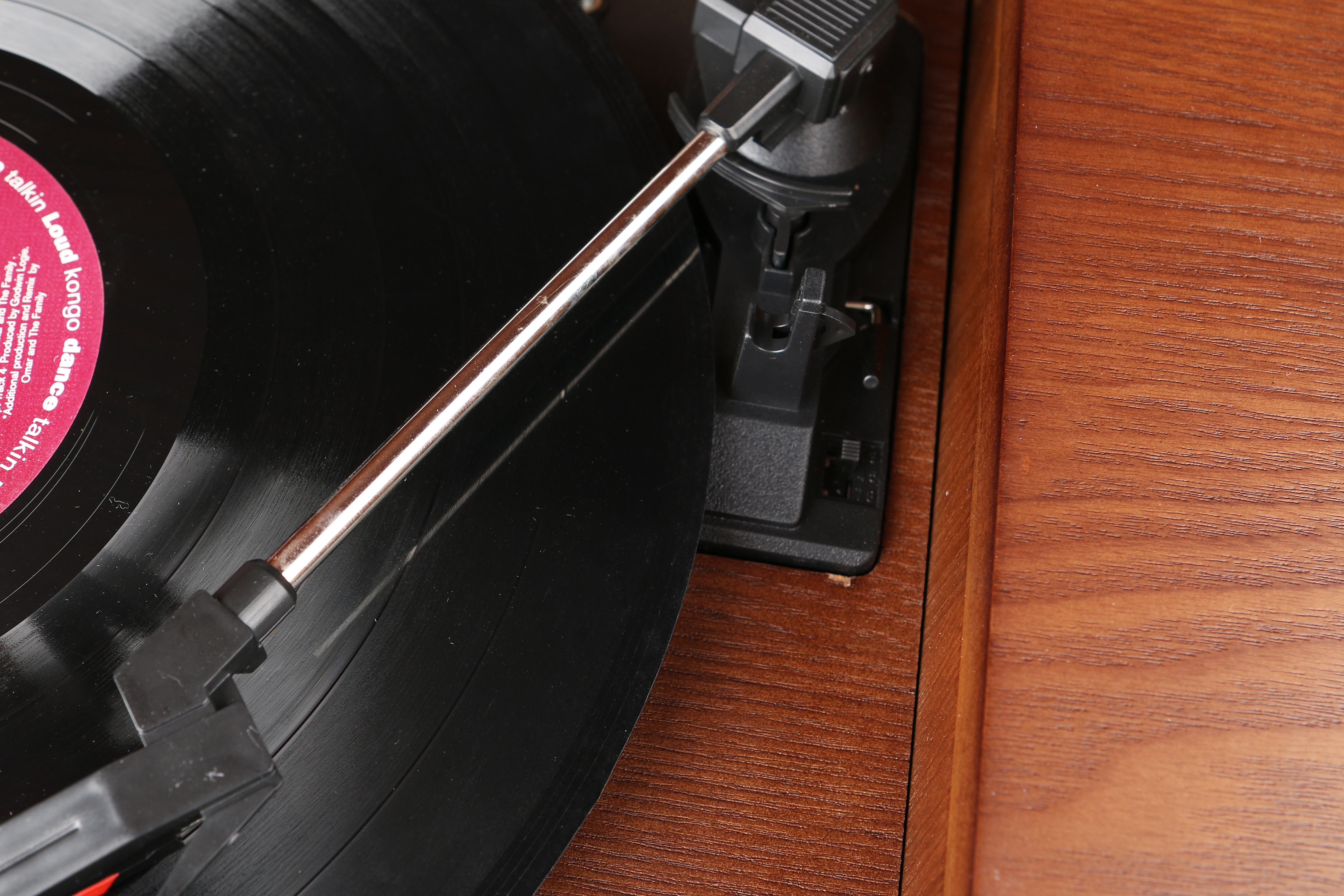 Nahaufnahme eines Plattenspielers mit einer schwarzen Vinylplatte. Die Nadel liegt auf der Platte.