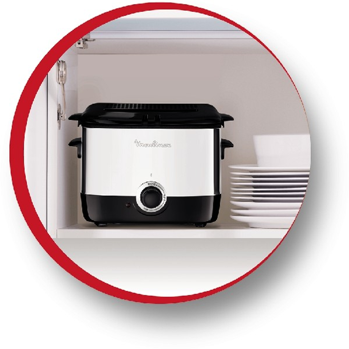 Biało-czarna frytkownica Moulinex w szafce, otoczona czerwonym okręgiem, z talerzami.