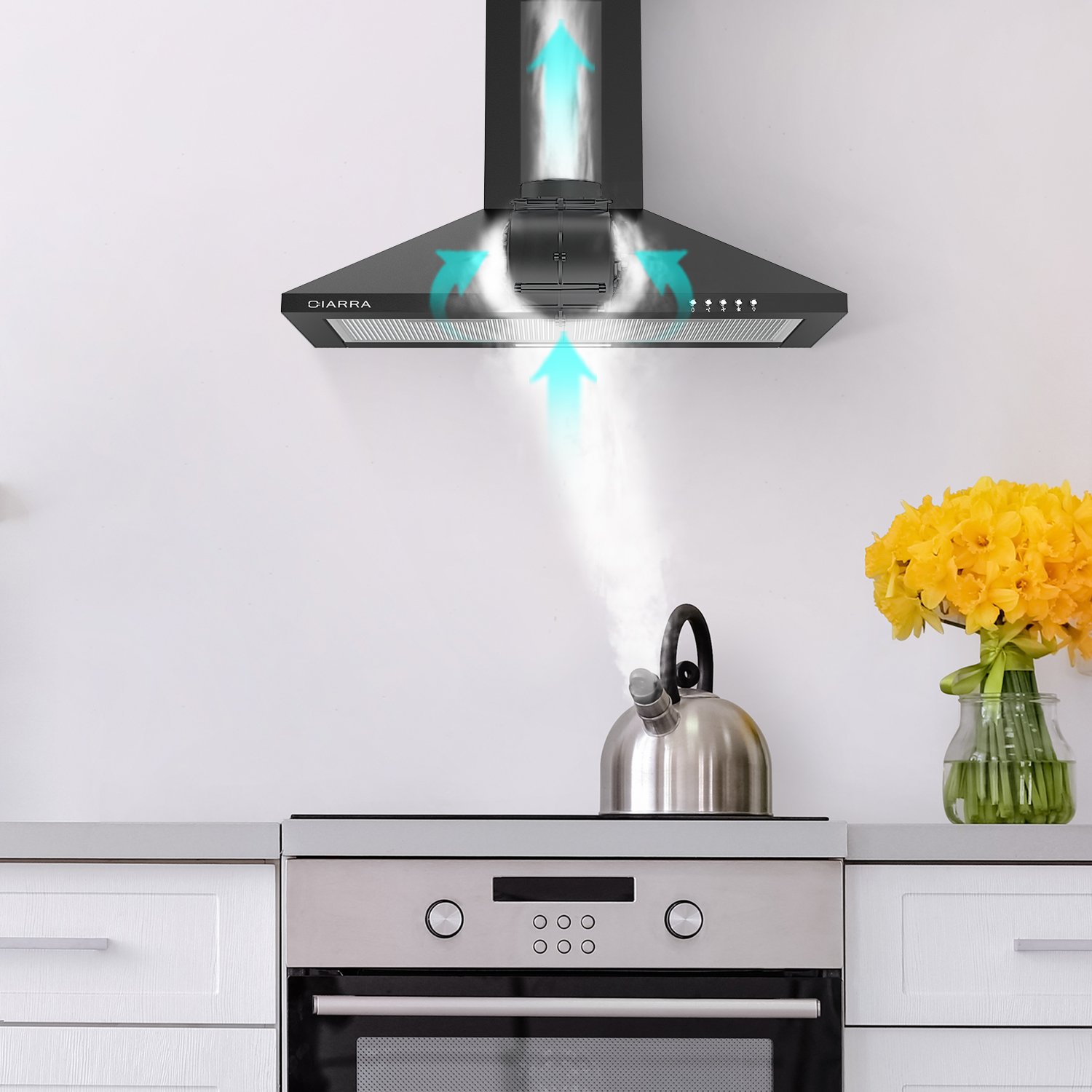 Escena de cocina con campana extractora negra, hervidor y flores en encimera blanca.