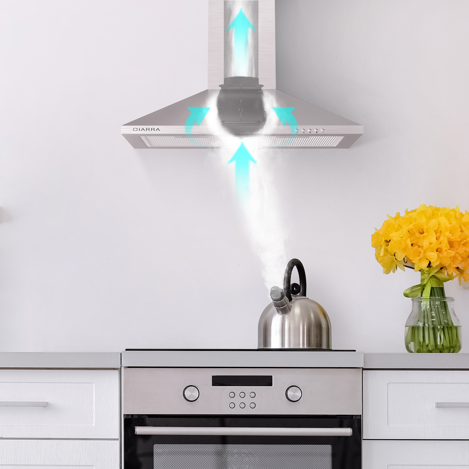 Escena de cocina. Campana de acero inoxidable con flechas azules. Tetera, flores amarillas, armarios y paredes blancos.