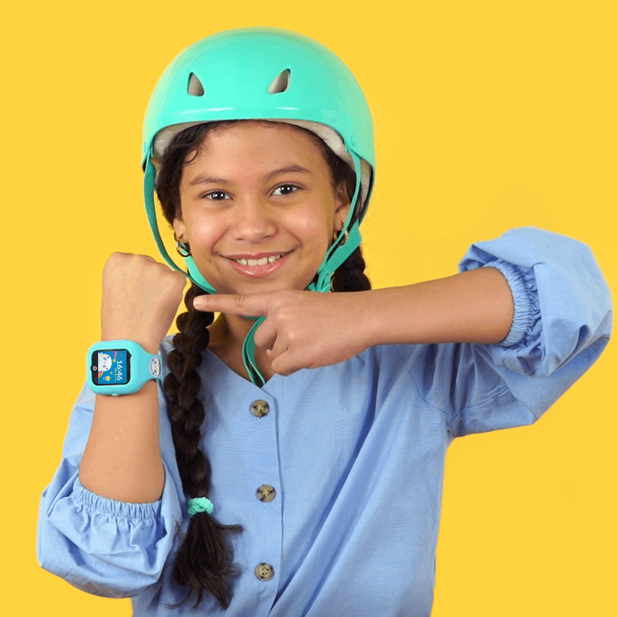 Niña con casco señala reloj inteligente azul. Fondo amarillo. Sonrisa.