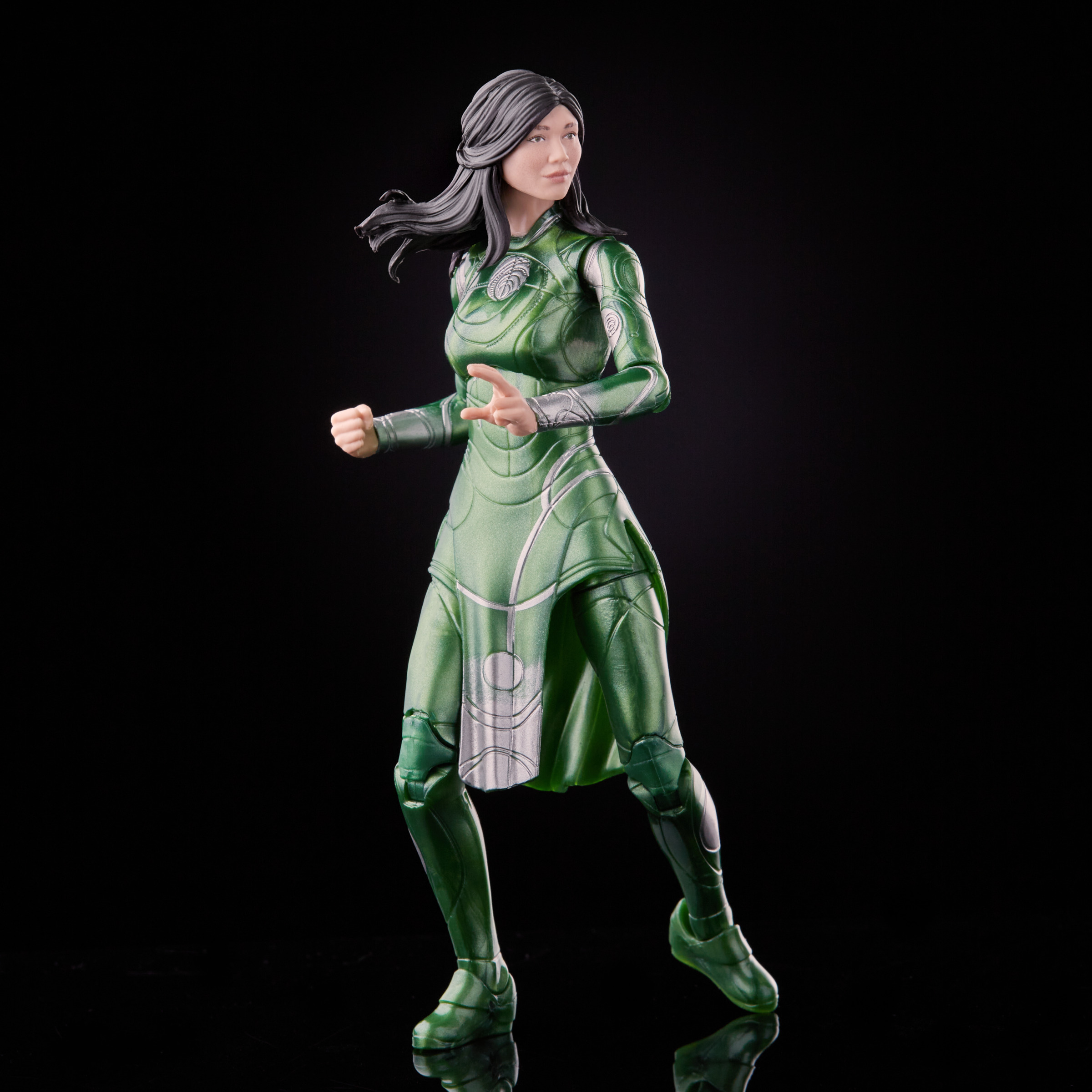 Una figura de acción femenina con un traje verde, de pie sobre una superficie negra.