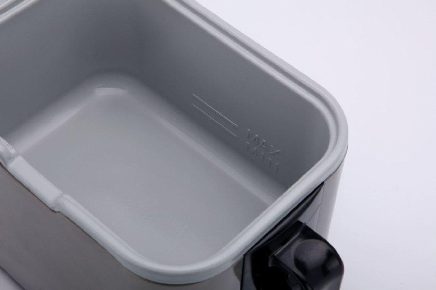 Zbliżenie szarego i czarnego wnętrza pojemnika. Pokazuje linie poziomu max i min.