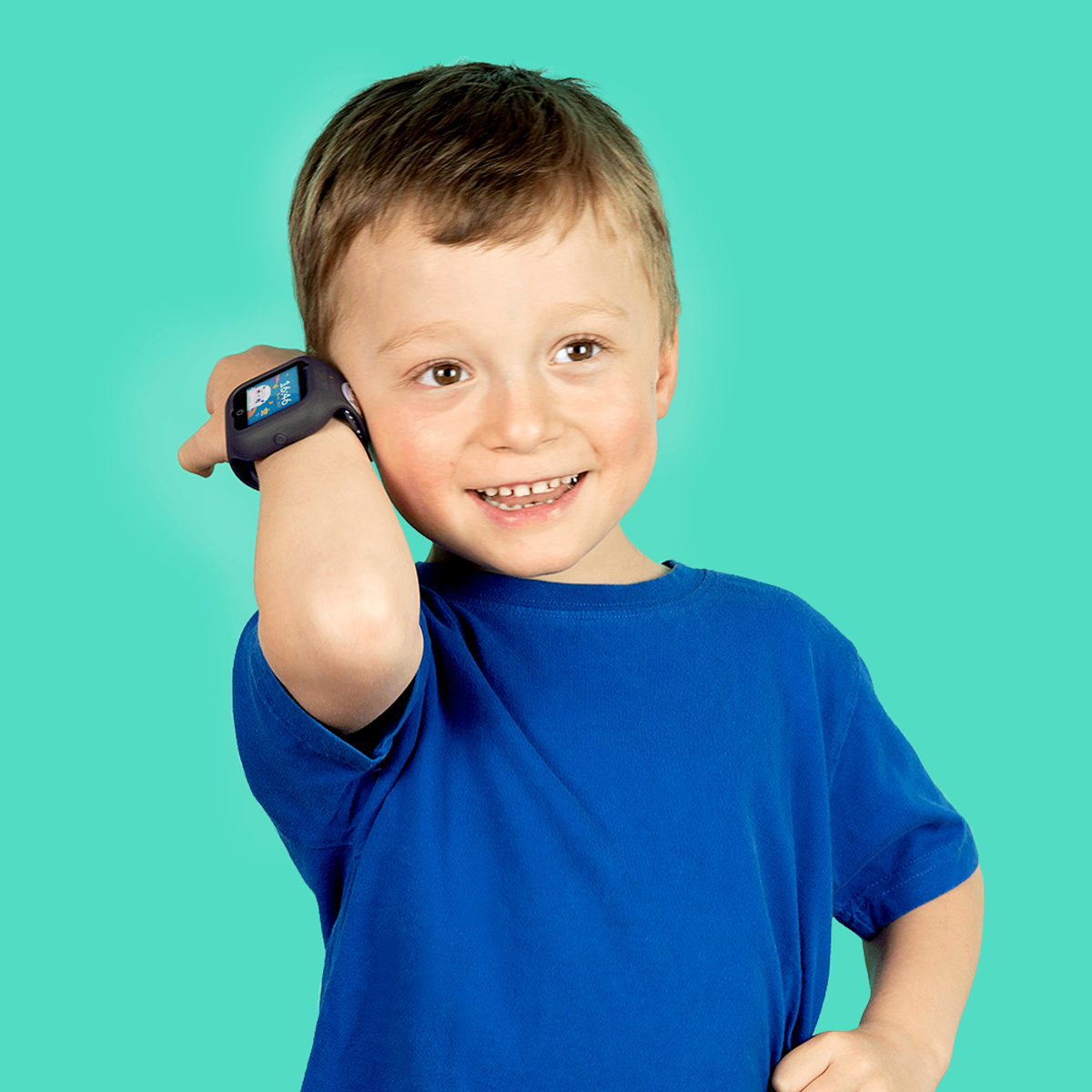 Niño pequeño usando un smartwatch. Sonriendo, camisa azul, piel clara, cabello claro. Fondo turquesa.