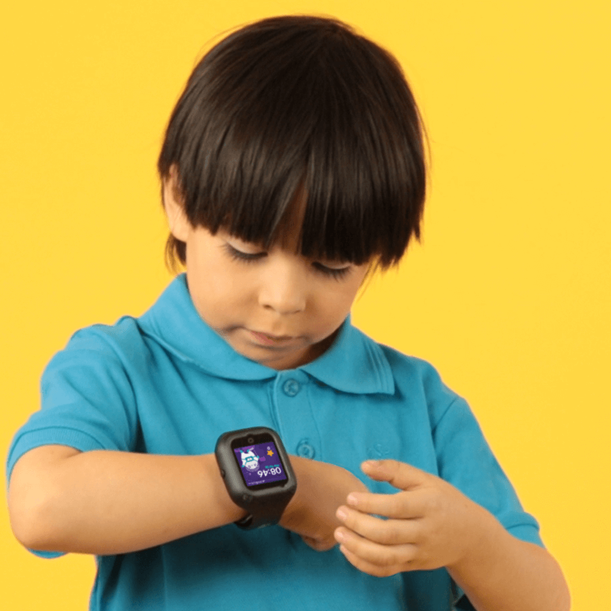 Un niño usando un reloj inteligente sobre fondo amarillo.