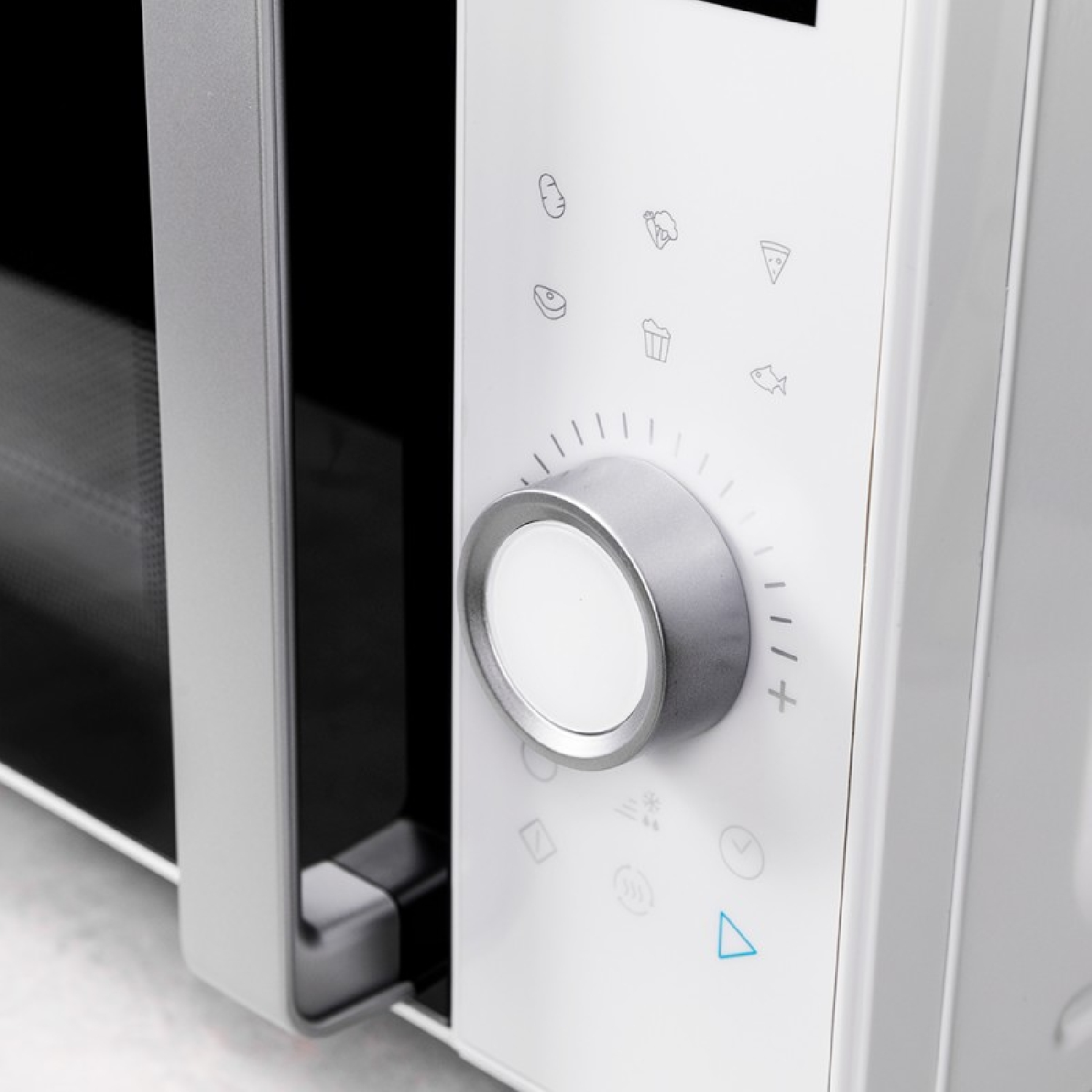 Panel sterowania kuchenki mikrofalowej. Biały panel z ikonami i srebrnym pokrętłem. Czarne szklane drzwi z lewej.