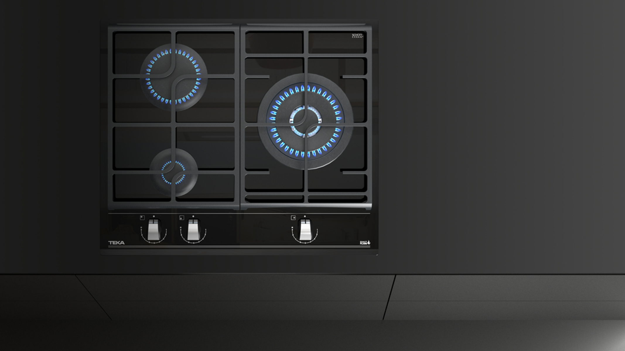 Czarna kuchenka z niebieskimi płomieniami. Trzy palniki są zapalone. Czarny blat.