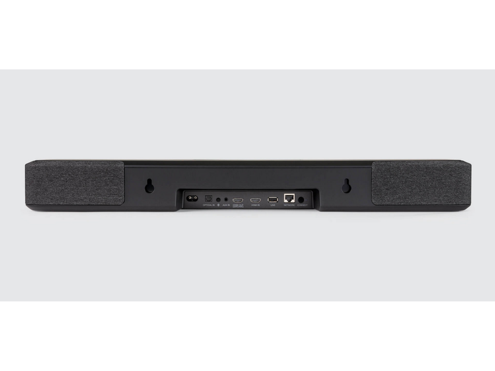 Black soundbar with fabric ends, showing the back with ports. The background is a light gray.